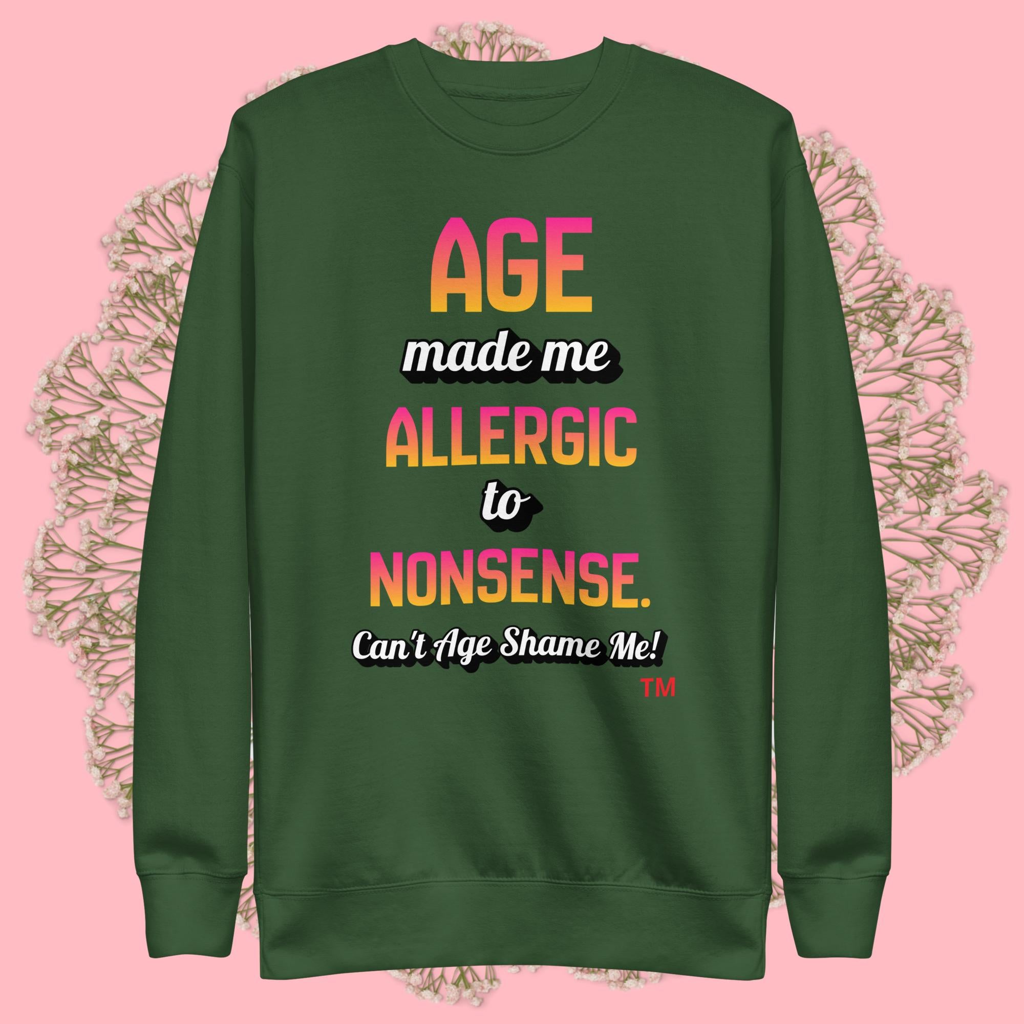 Green sweatshirt with colorful text on a pink background
