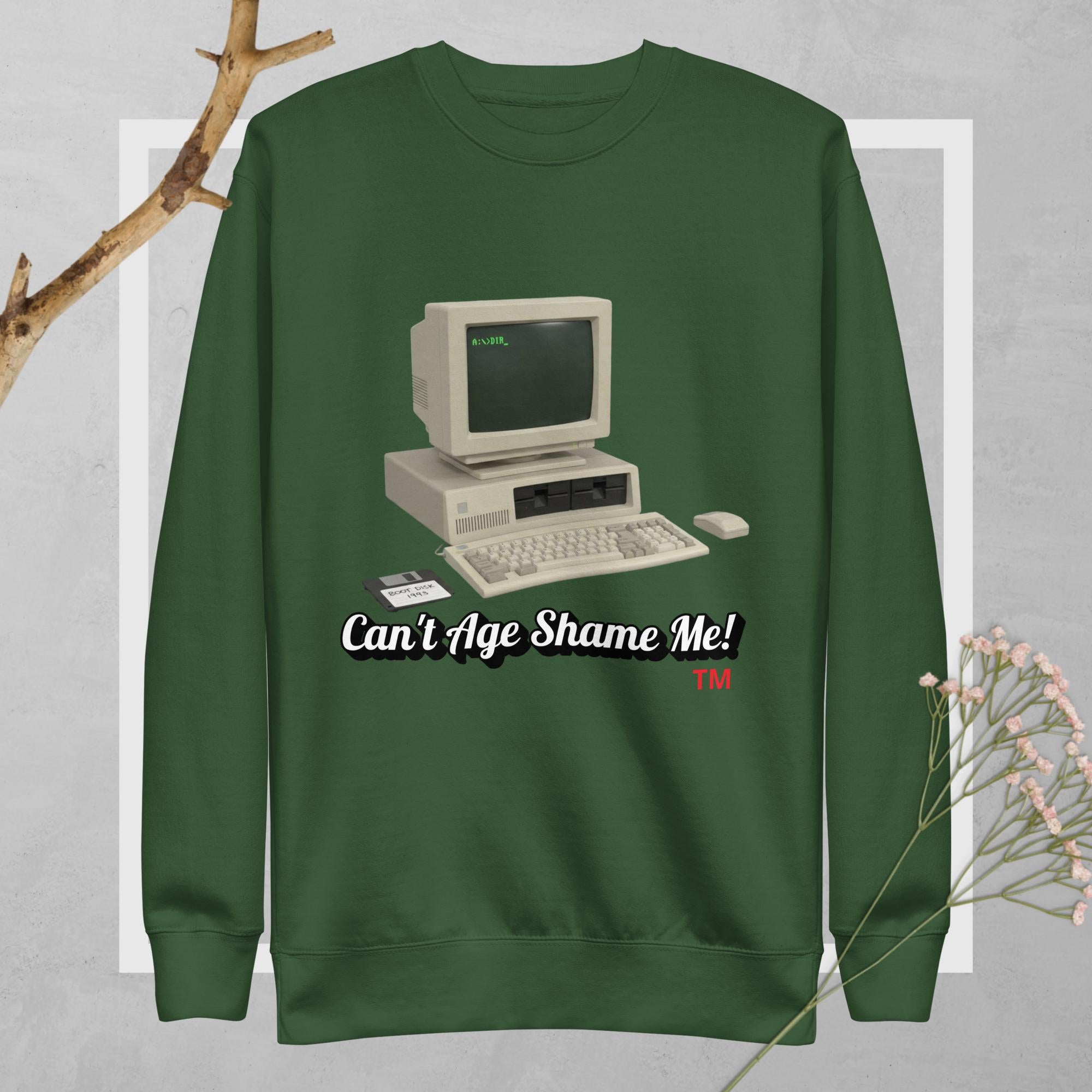 Green sweatshirt with vintage computer graphic and text 'Can't Age Shame Me!' on a gray background.