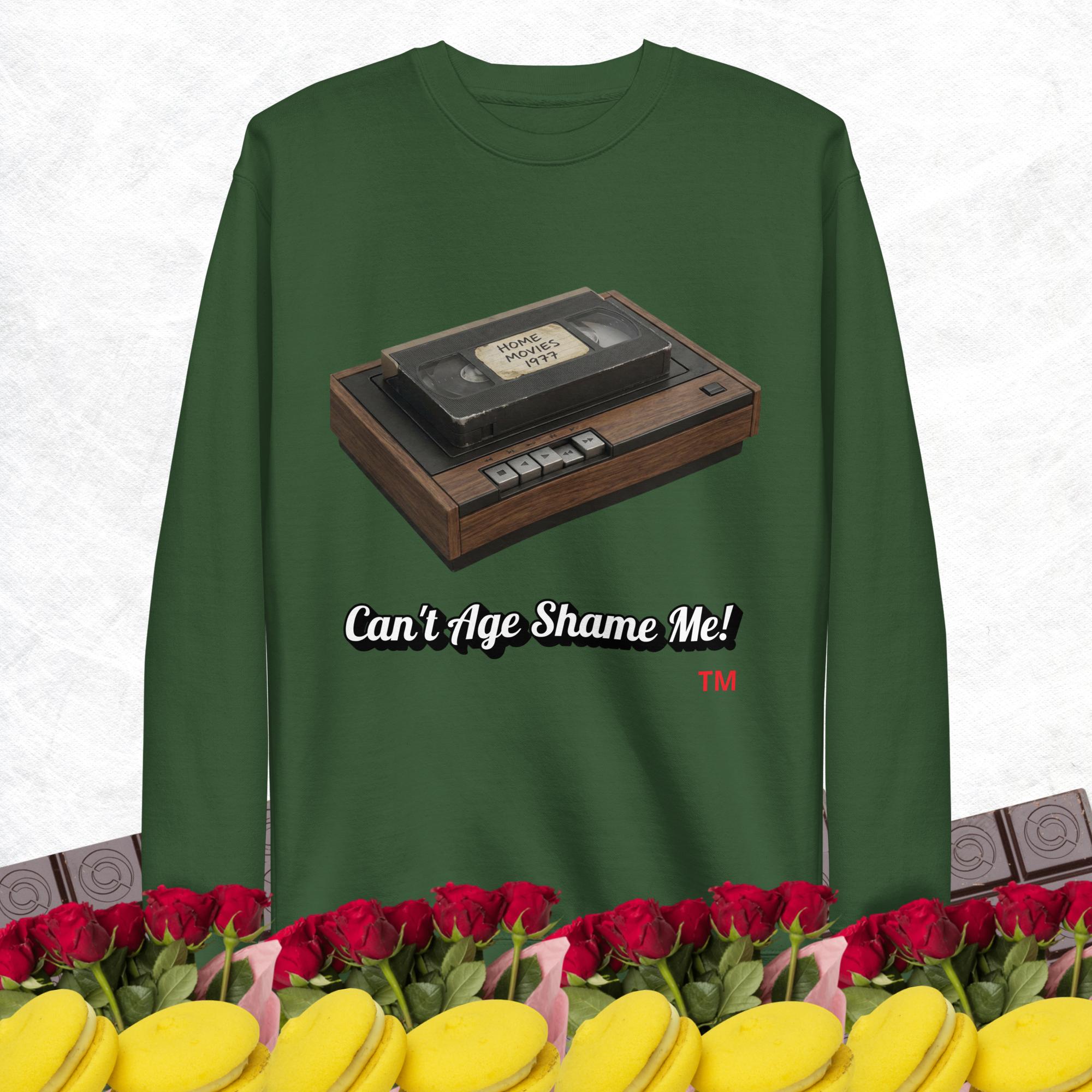 Green sweatshirt with a vintage VHS tape design and text 'Can't Age Shame Me!' on a white background.