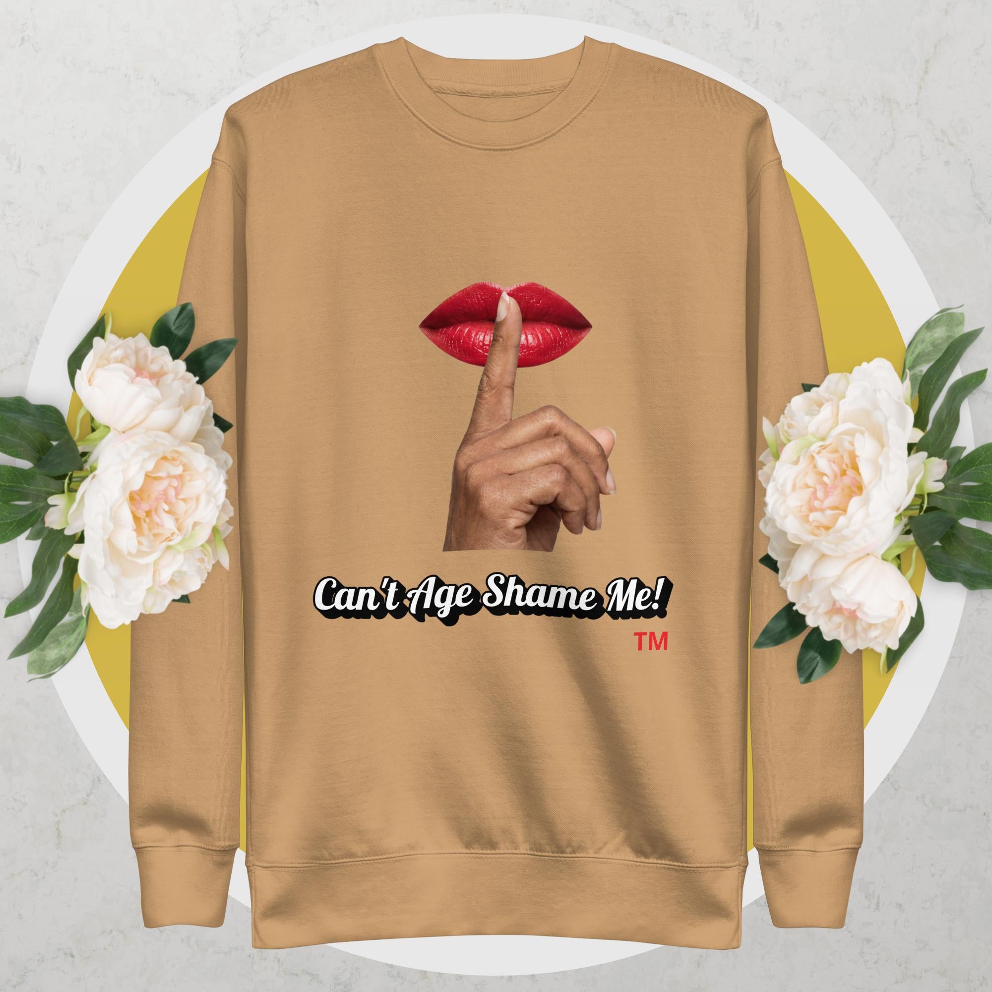 Khaki sweatshirt with graphic design of a hand, lips, and text 'Can't Age Shame Me!' on a floral background.