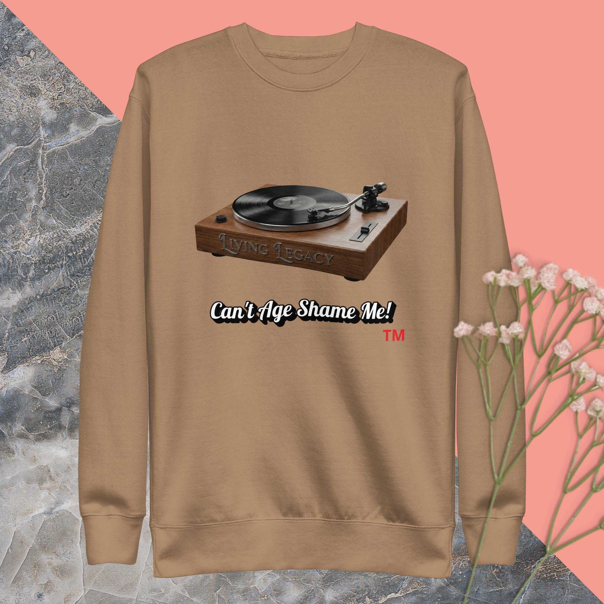 latte  sweatshirt with a record player graphic and text can't age shame me ! on a pink and gray background