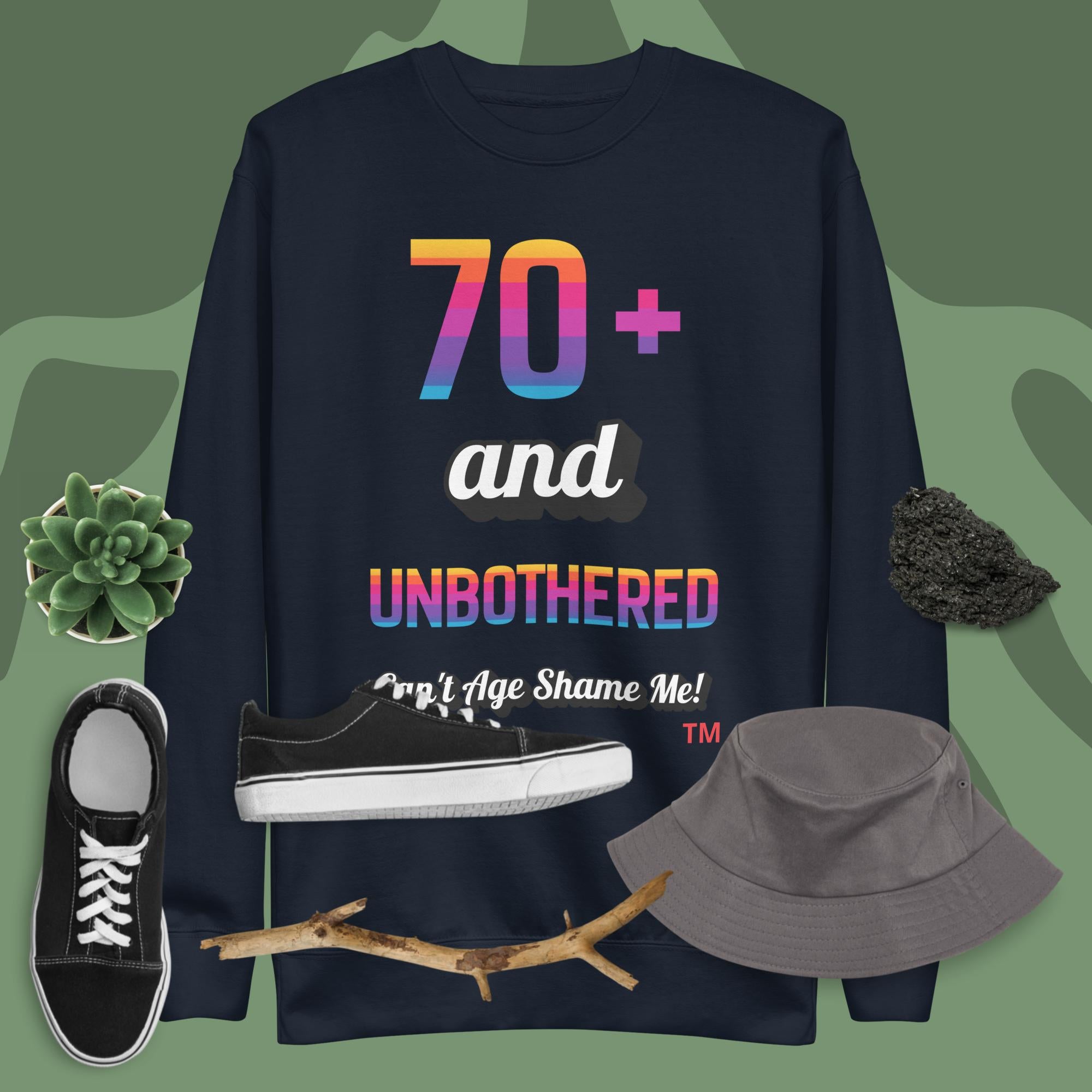 Navy sweatshirt with colorful text, black sneakers, gray hat, and branch on a green background