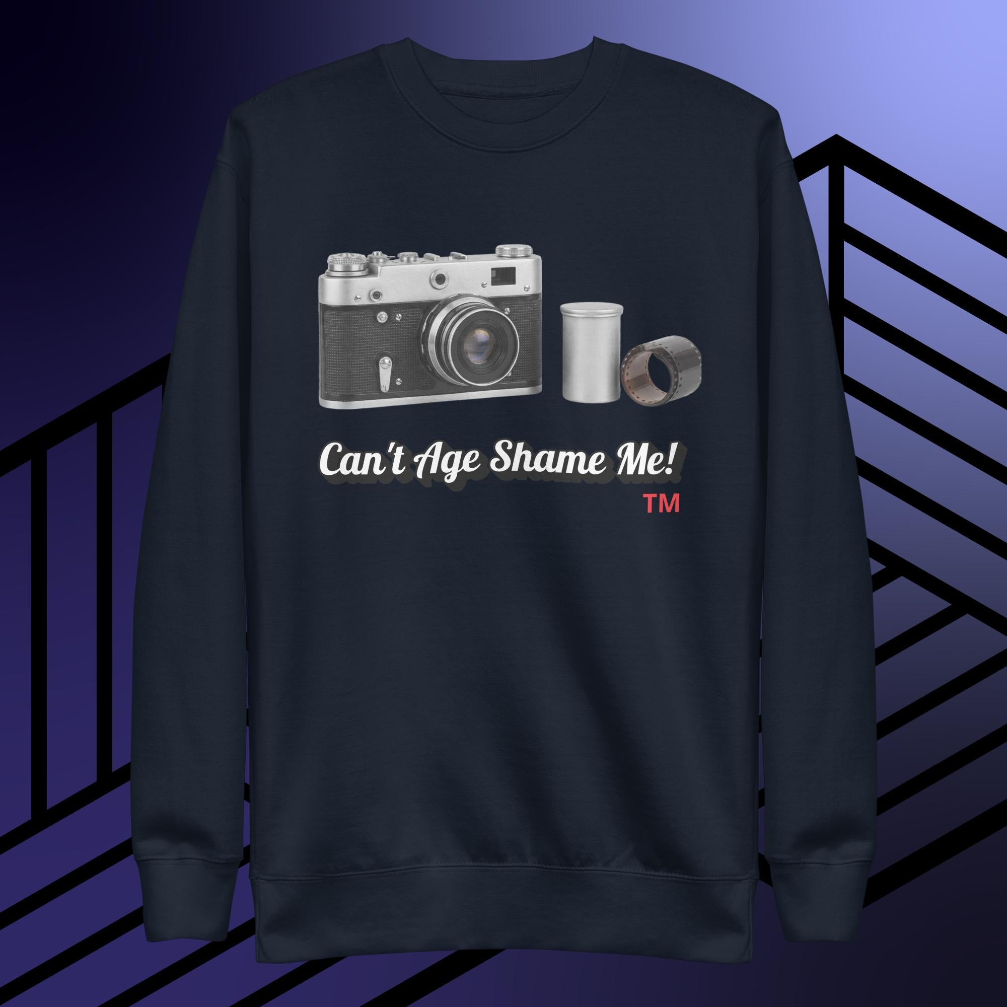 navy sweatshirt with camera graphic and text 'Can't Age Shame Me!' on a striped background