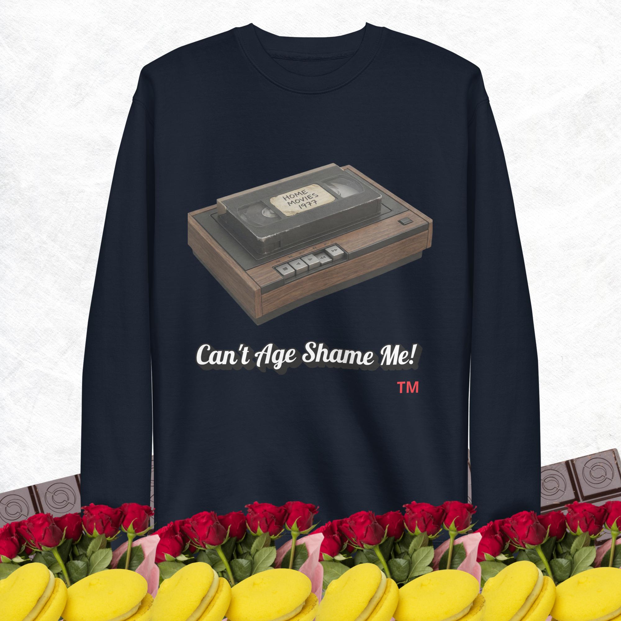 Navy blue sweatshirt with a cassette tape graphic and text 'Can't Age Shame Me!' on a white background, surrounded by roses and cookies.