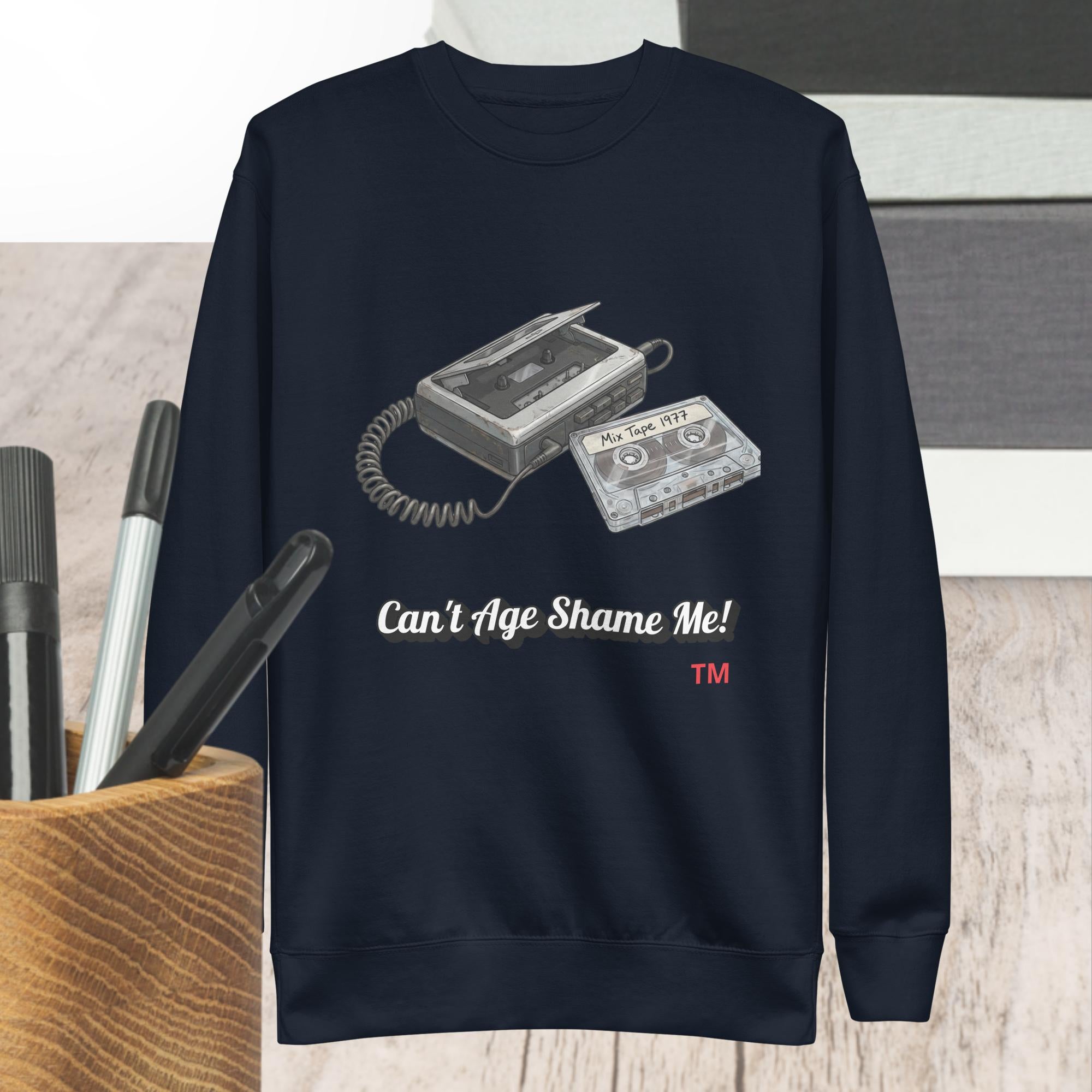 Navy blue sweatshirt with cassette tape design and text 'Can't Age Shame Me!' on a neutral background.