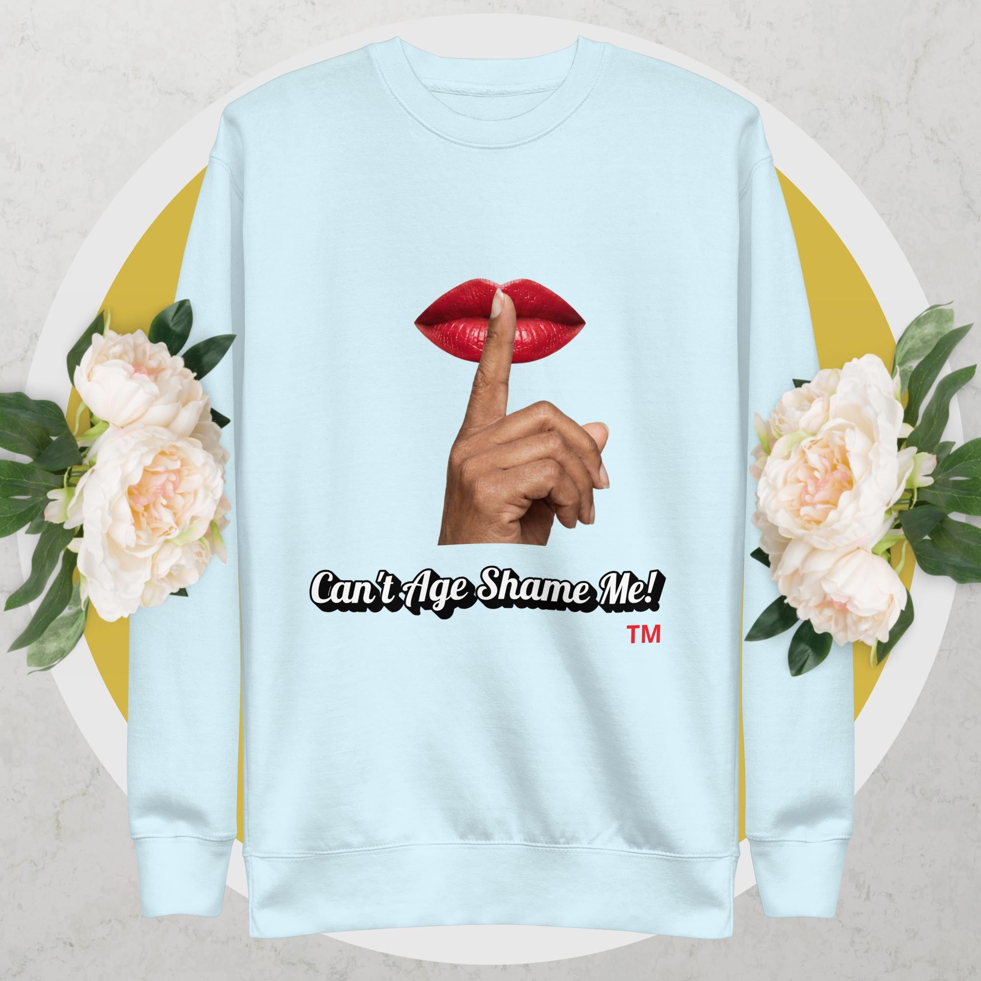 Sky Blue sweatshirt with graphic design of a hand, lips, and text 'Can't Age Shame Me!' on a floral background.