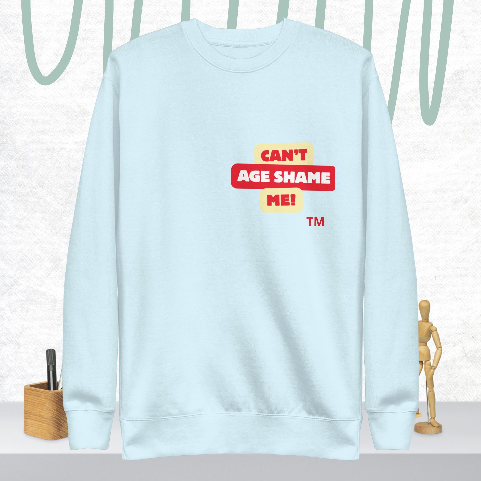Sky Blue sweatshirt with 'CAN'T AGE SHAME ME!' text logo on a light gray background