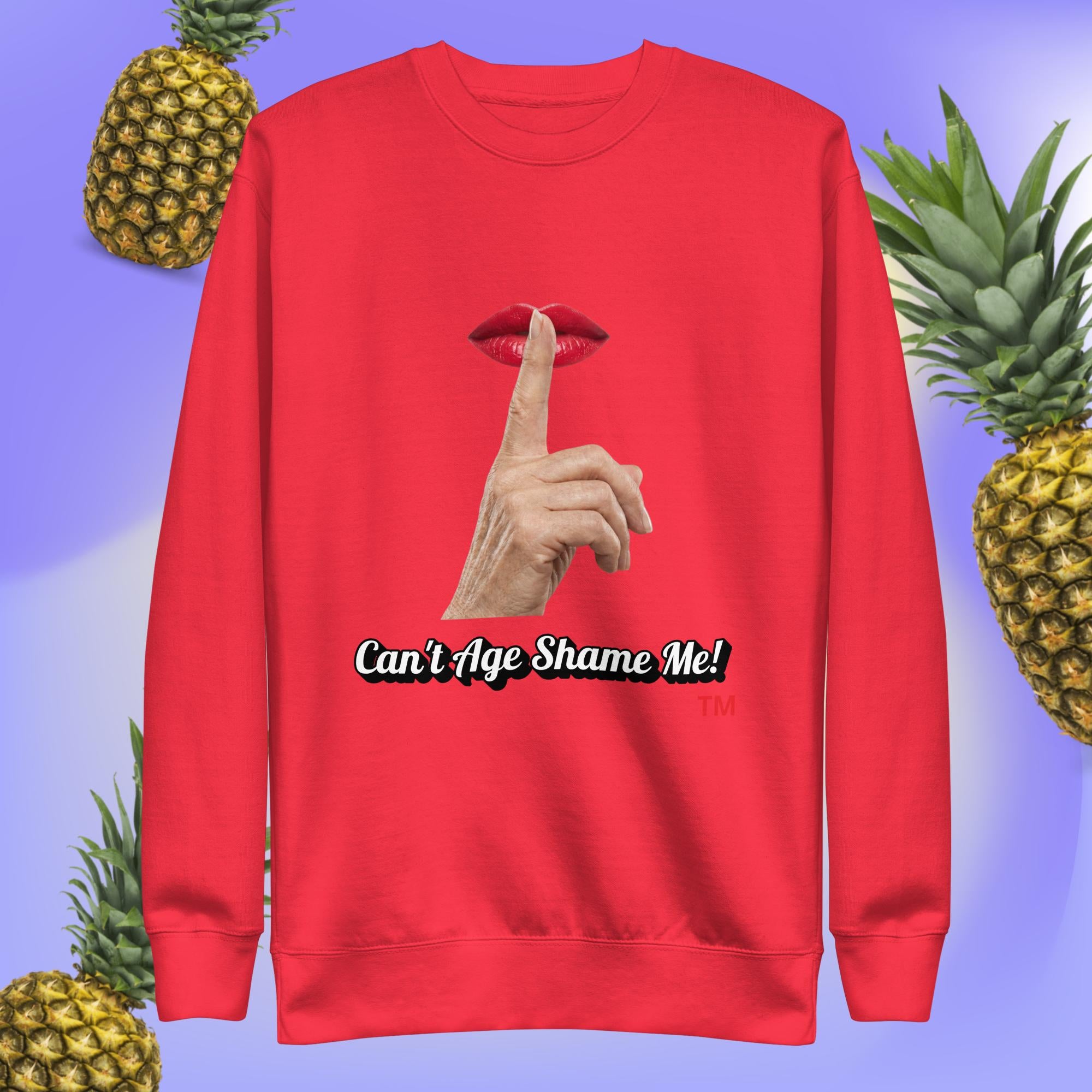 Team Red sweatshirt with a graphic design of finger on mouth and text 'Can't Age Shame Me!' on a blue background with pineapples.