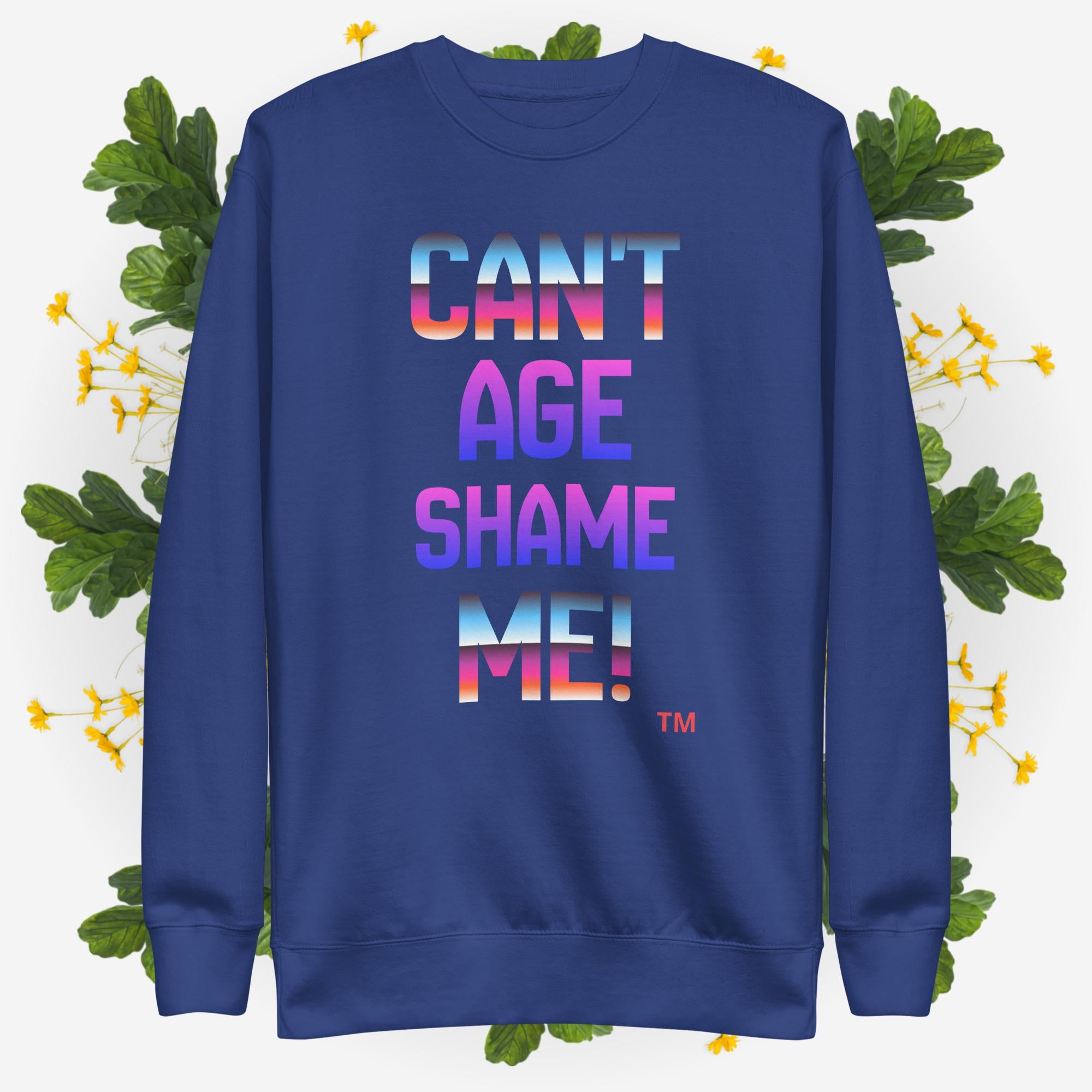 Blue sweatshirt with colorful text 'CAN'T AGE SHAME ME!' on a floral background
