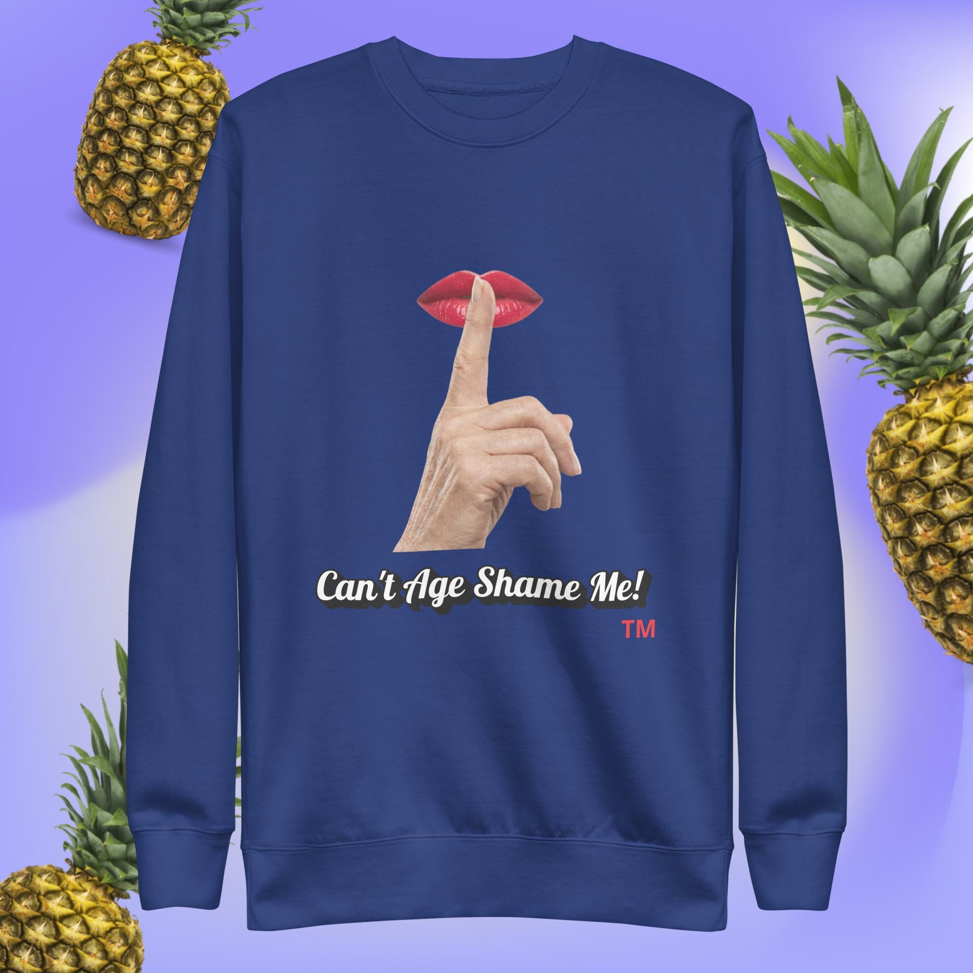 Team Royal sweatshirt with a graphic design of finger on mouth and text 'Can't Age Shame Me!' on a blue background with pineapples.