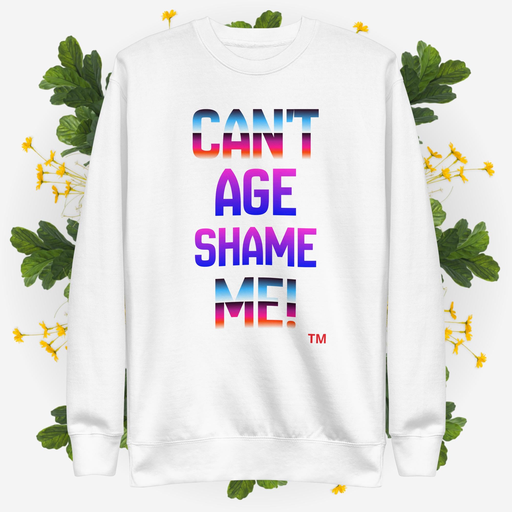 White sweatshirt with colorful text 'CAN'T AGE SHAME ME!' on a floral background