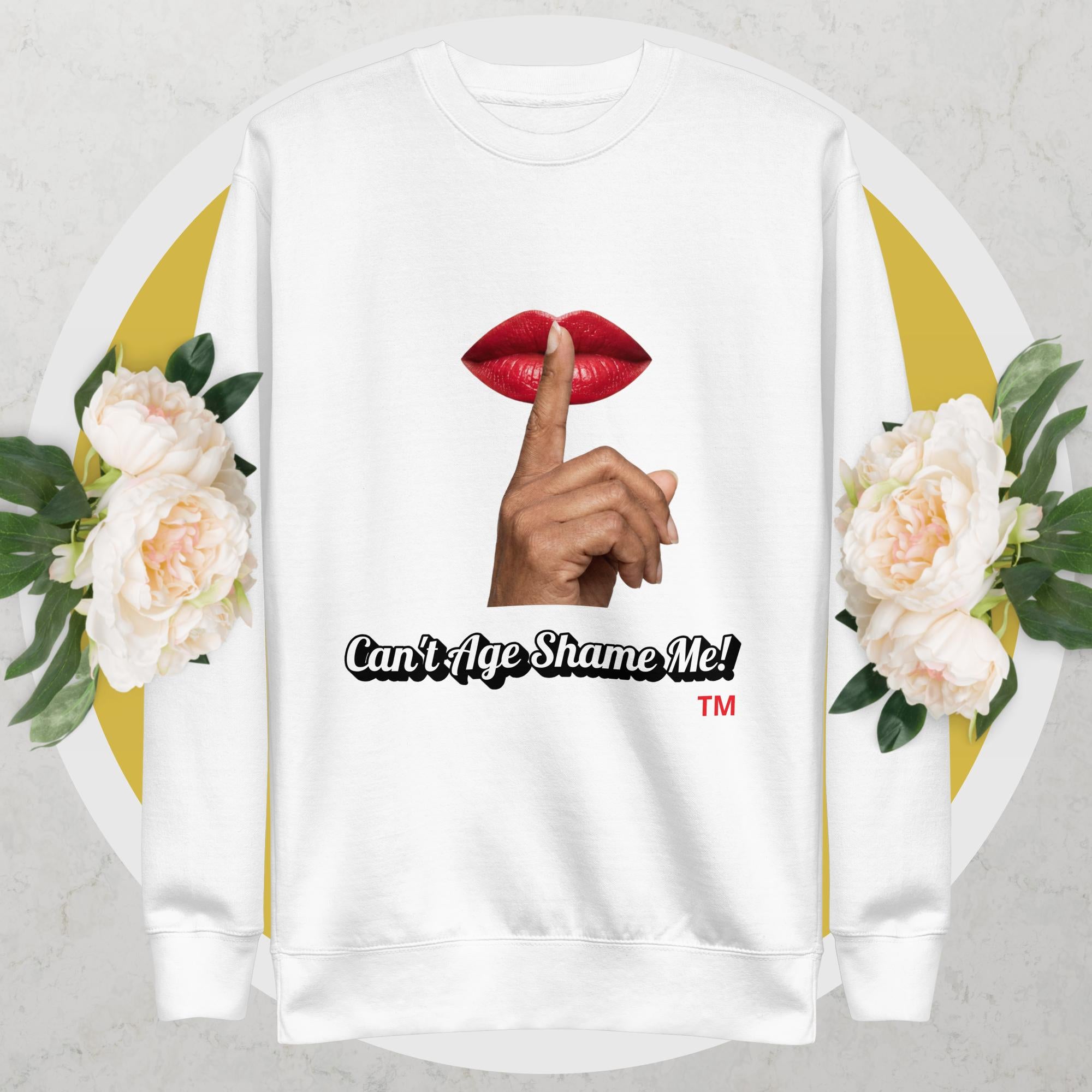 White sweatshirt with graphic design of a hand, lips, and text 'Can't Age Shame Me!' on a floral background.