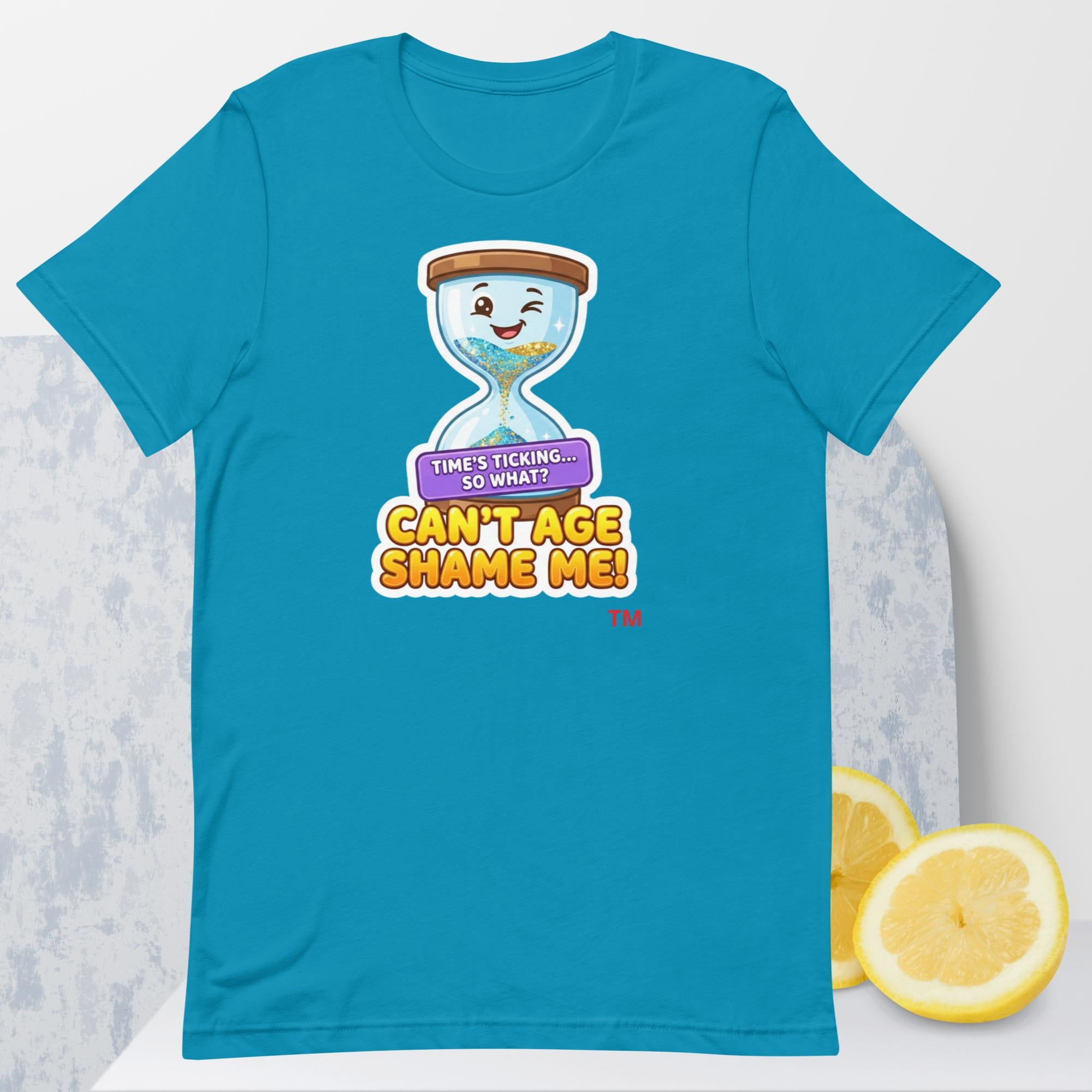 Aqua t-shirt with a cartoon hourglass design and text 'Can't Age Shame Me' graphic on a light gray background.

