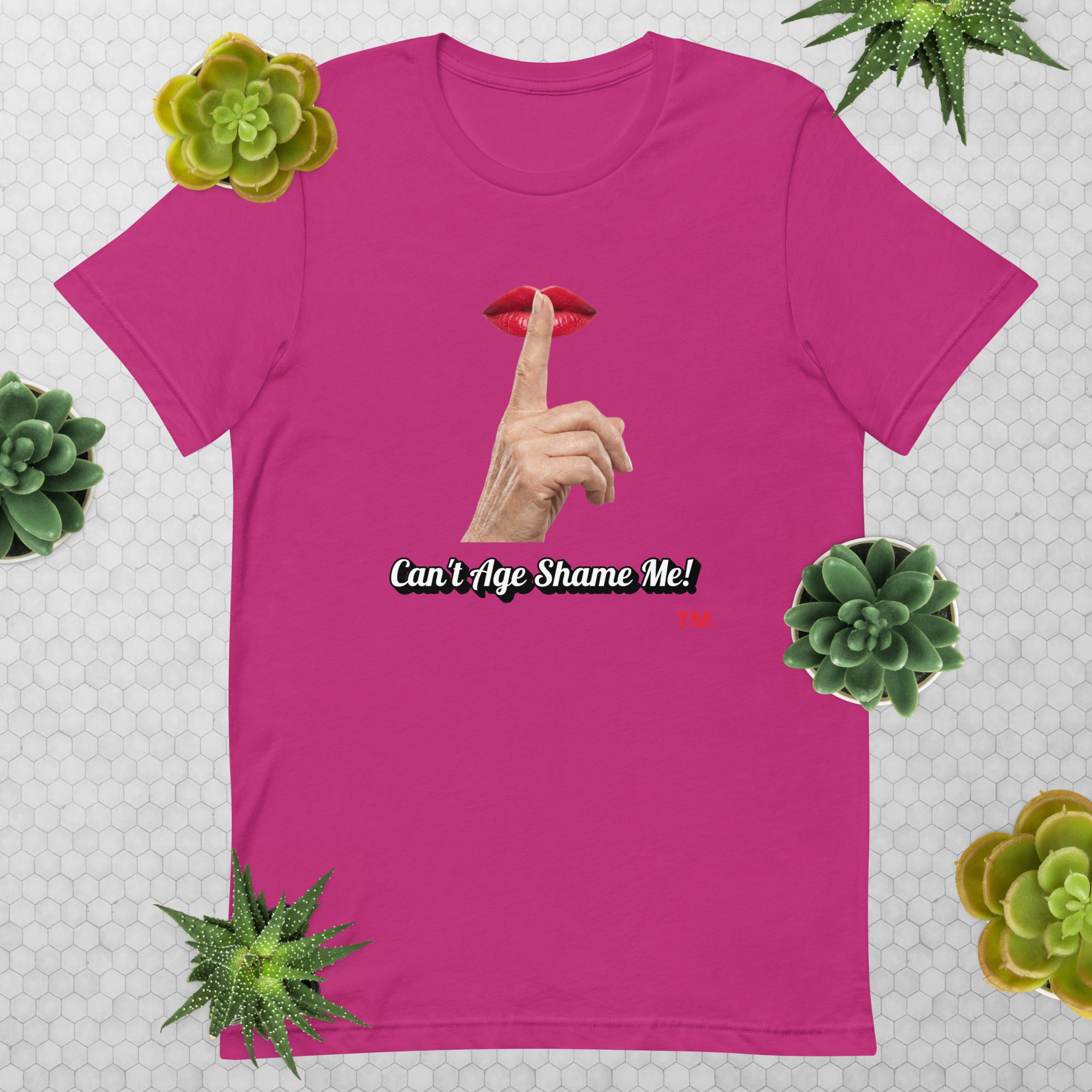 Berry t-shirt with graphic design of finger on mouth and text 'CAN'T AGE SHAME ME!' text logo on a light gray background with succulents.