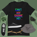 Black t-shirt with colorful text, black sneakers, gray bucket hat, and branch on a green background
