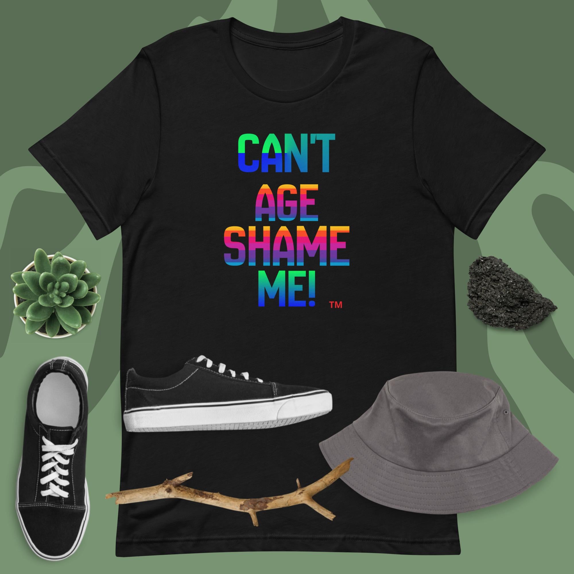 Black t-shirt with colorful text, black sneakers, gray bucket hat, and branch on a green background