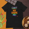 Black t-shirt with colorful text 'CAN'T AGE SHAME ME!' on a brown background with chocolate and flowers.