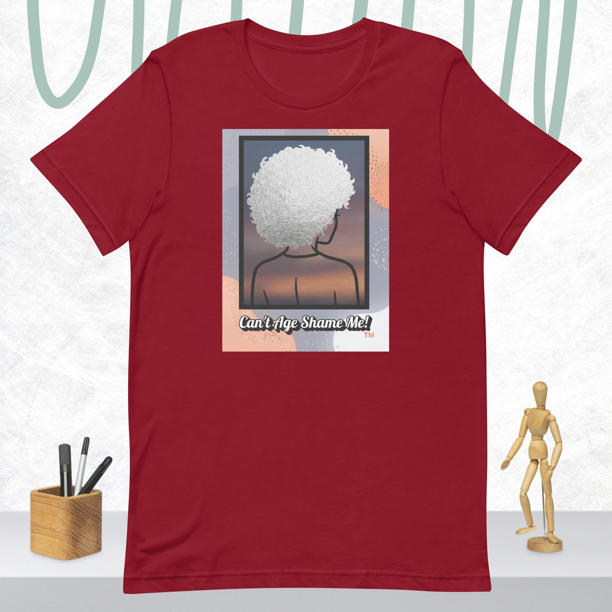 Cardinal  t-shirt with a graphic of a person with an afro and text 'Can't Age Shame Me!' on a white background.