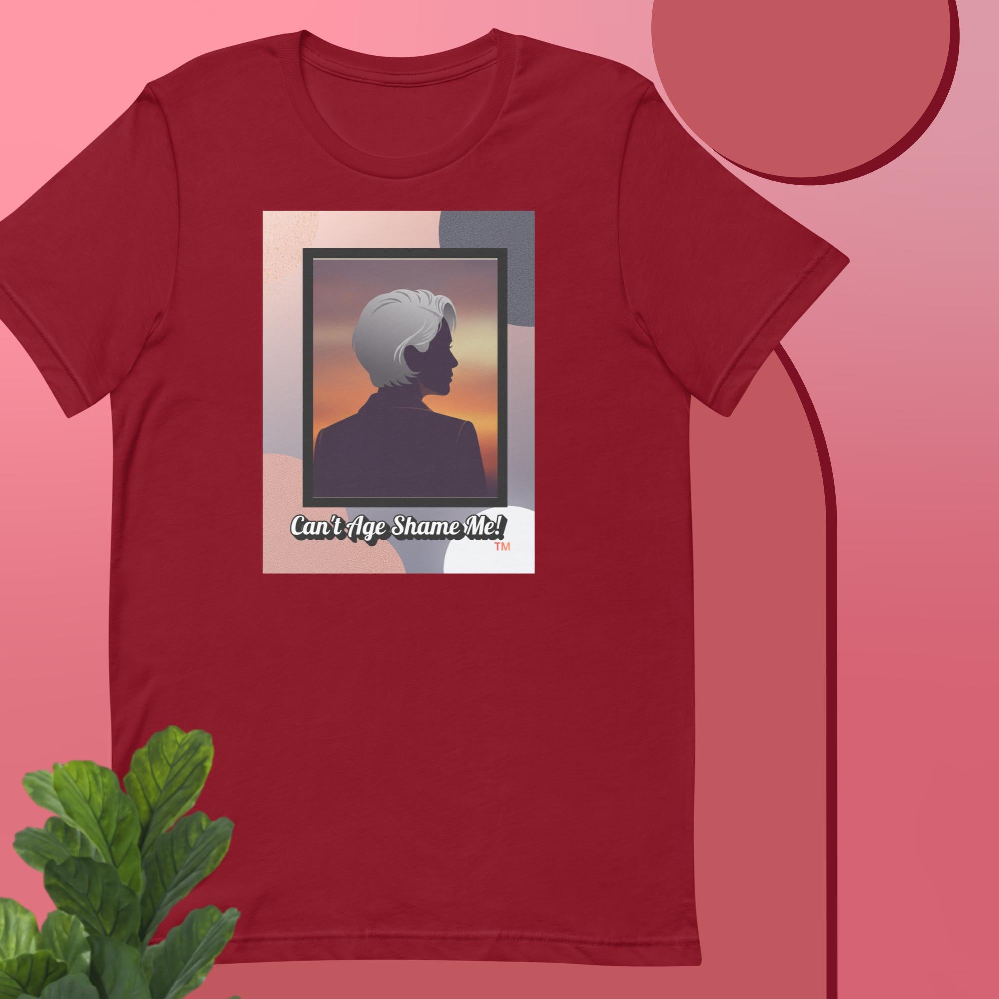 Cardinal t-shirt with a graphic design featuring a woman with gray hair silhouette and text: Can’t Age Shame Me! on a pink background.


