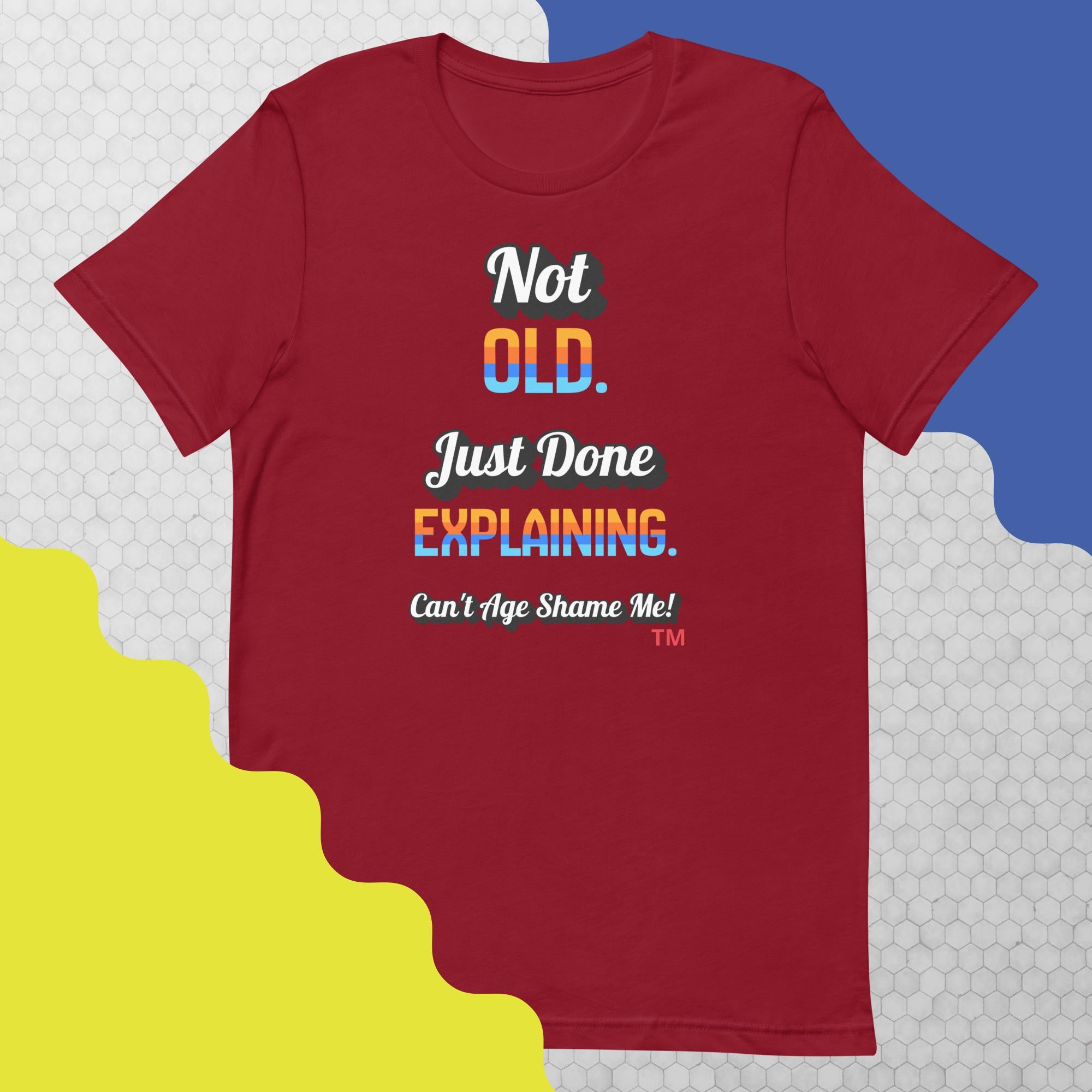 Red t-shirt with colorful text design on a geometric patterned background