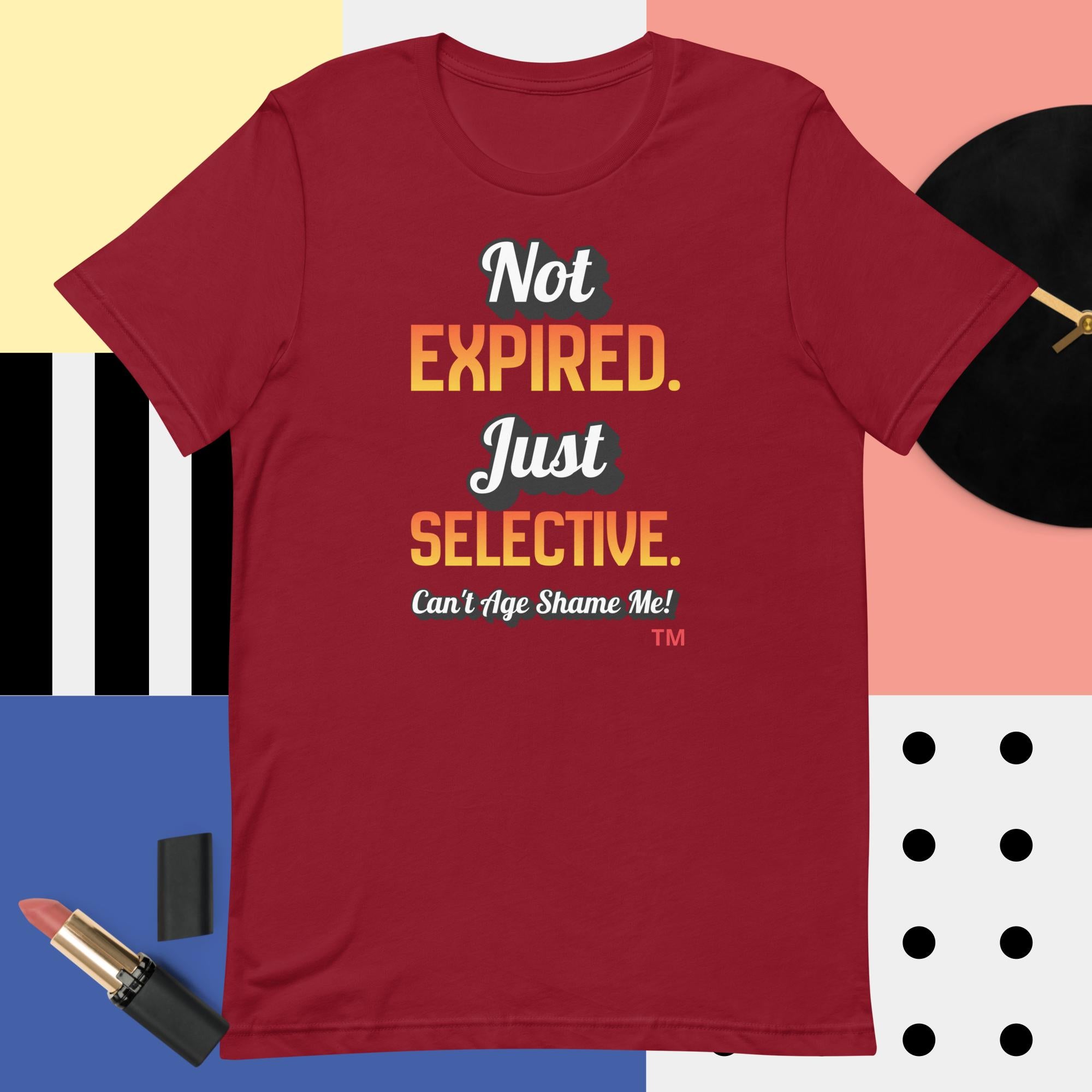 Red t-shirt with humorous text design on a colorful geometric background
