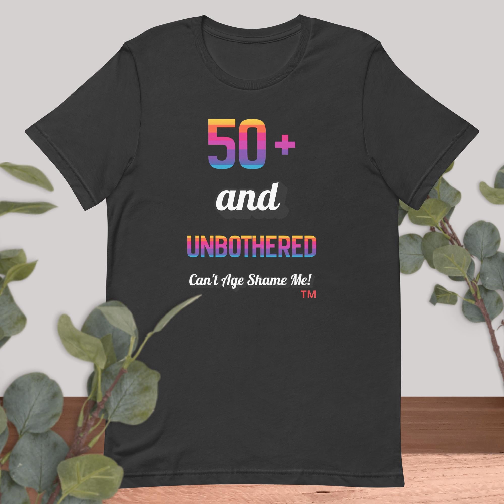 Dark gray t-shirt with colorful text design on a light background with greenery
