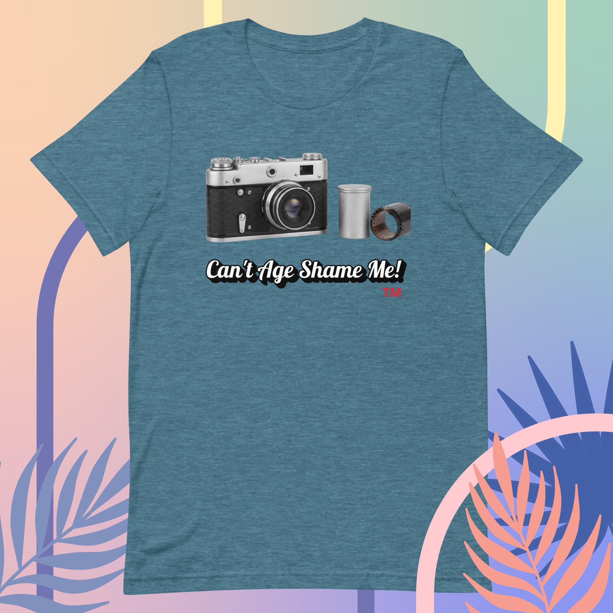 teal t-shirt with a camera graphic and text 'Can't Age Shame Me!' on a colorful abstract background.