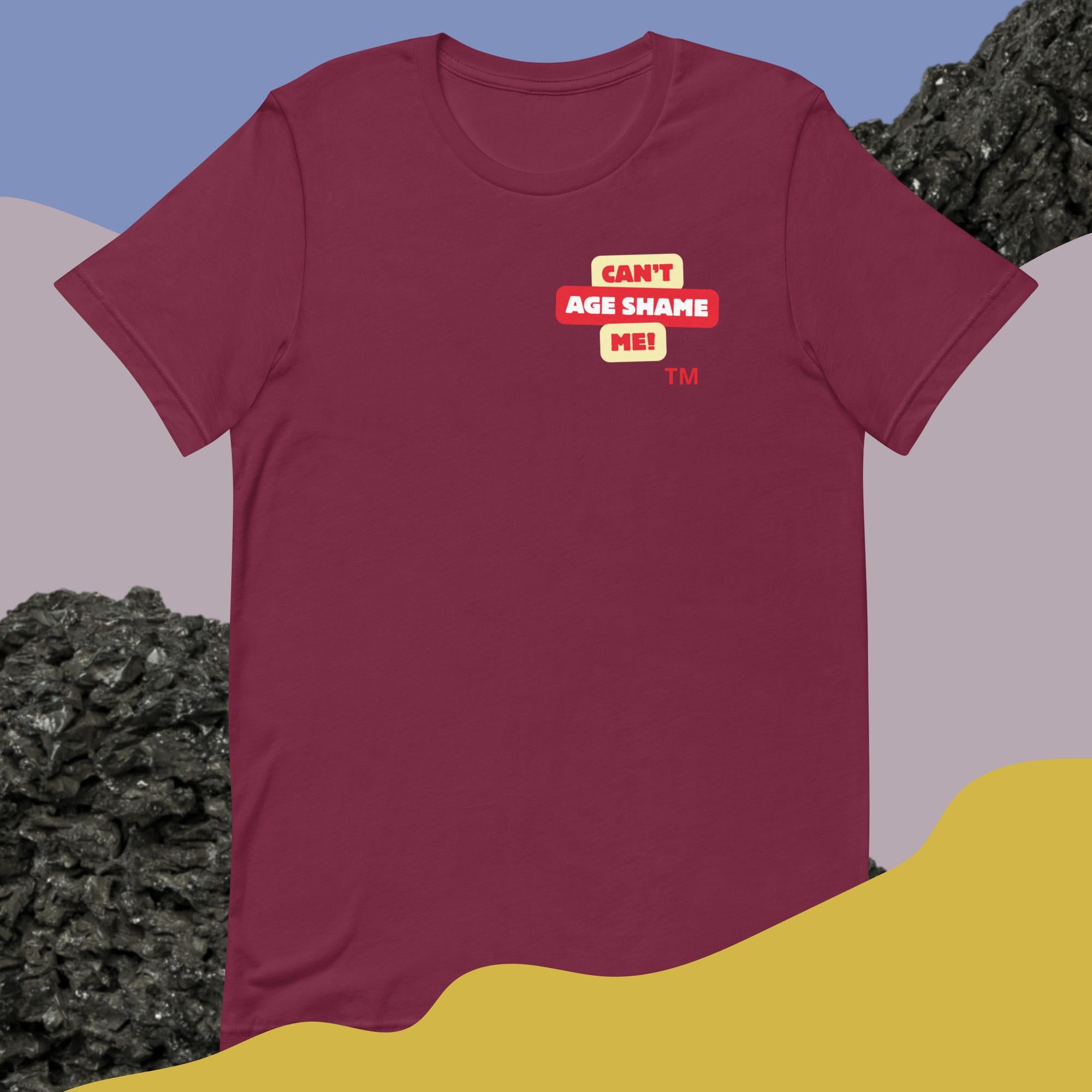 Maroon t-shirt with a logo text graphic 'CAN'T AGE SHAME ME! design on a colorful abstract background