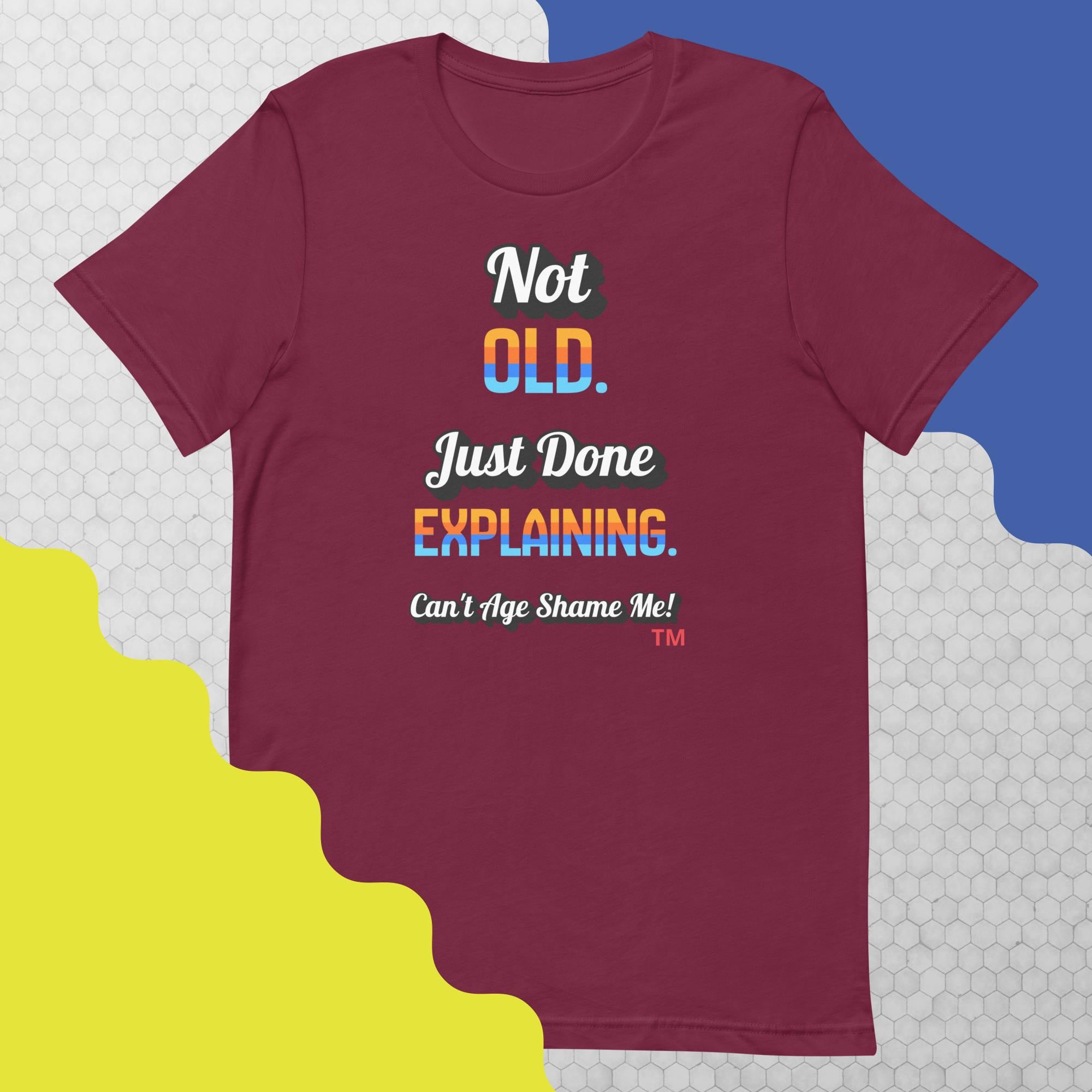 Maroon t-shirt with colorful text on a geometric patterned background