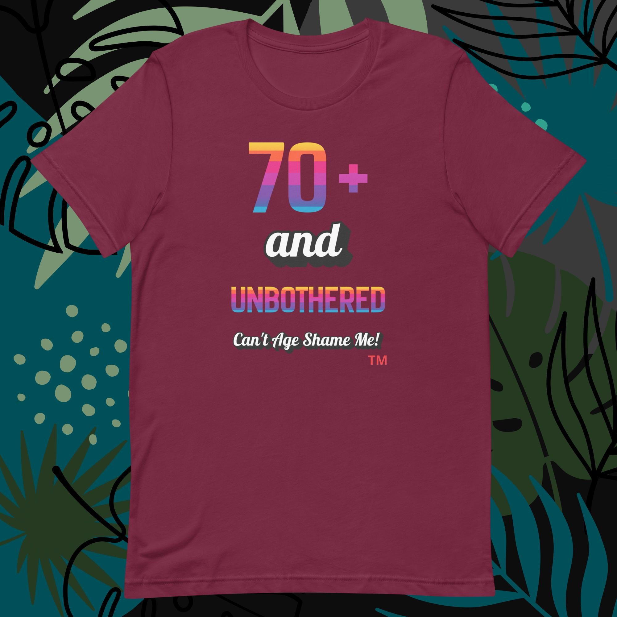 Maroon t-shirt with colorful text design on a decorative background
