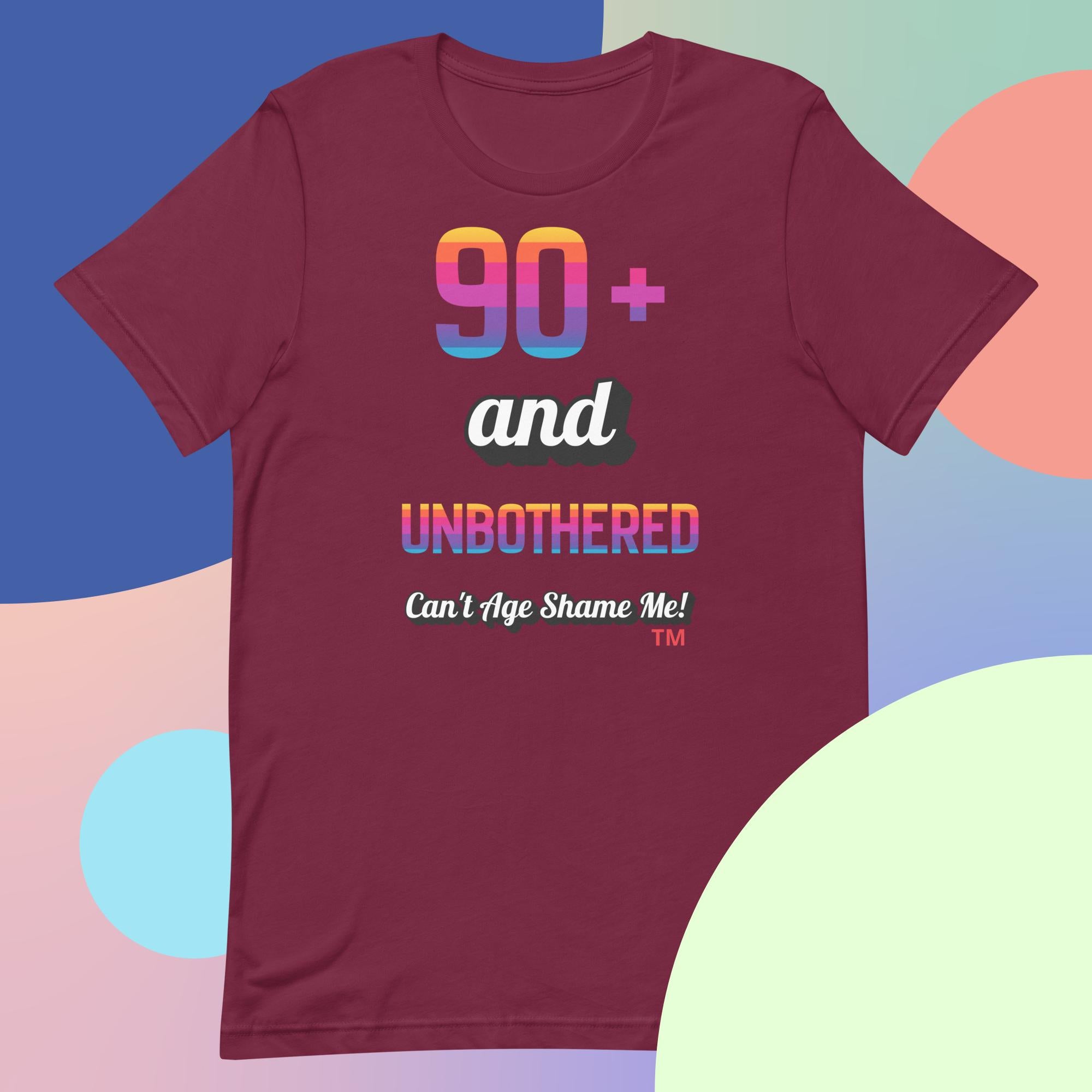 Maroon t-shirt with colorful text design on a multicolored background