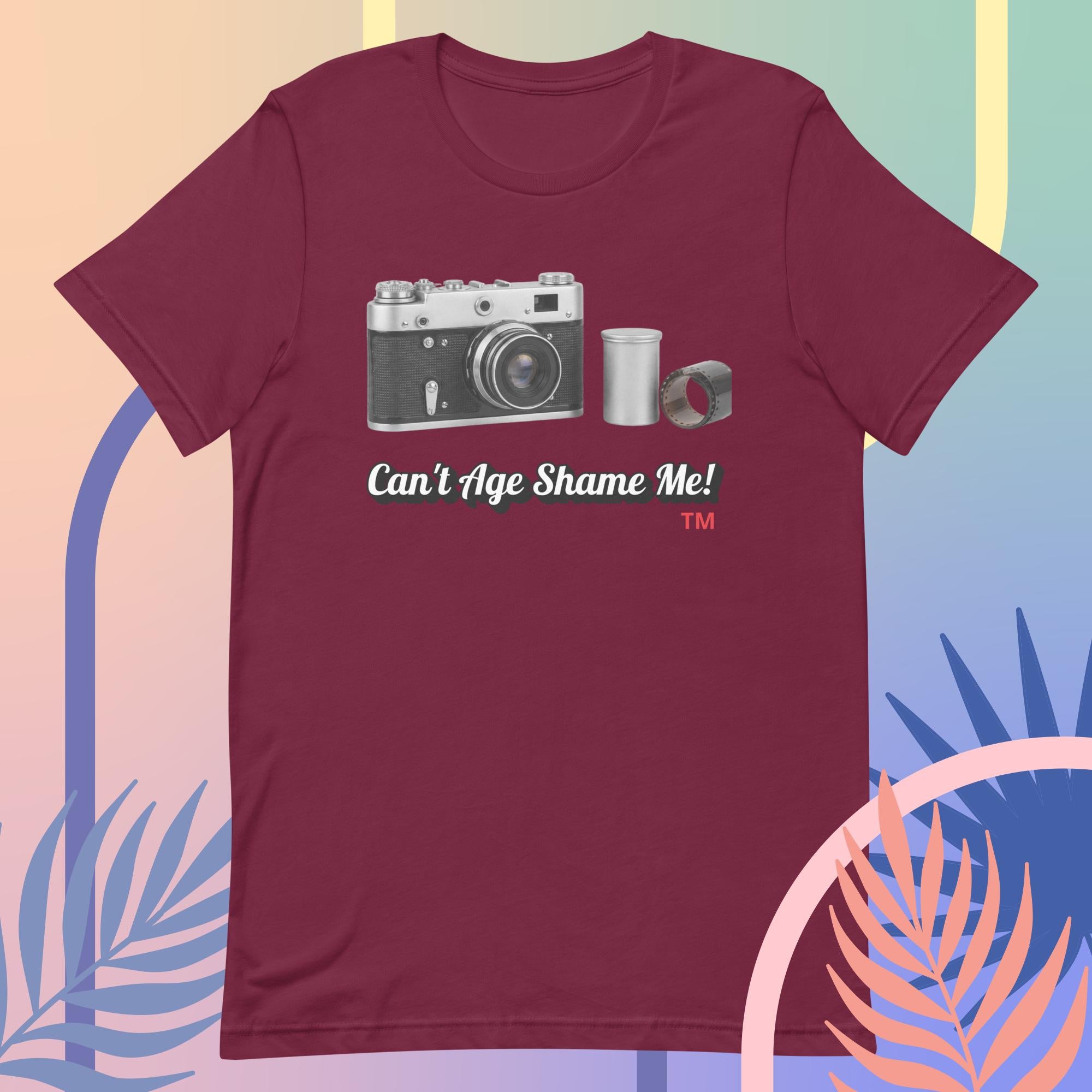 Maroon t-shirt with camera graphic and text 'Can't Age Shame Me!' on a colorful background