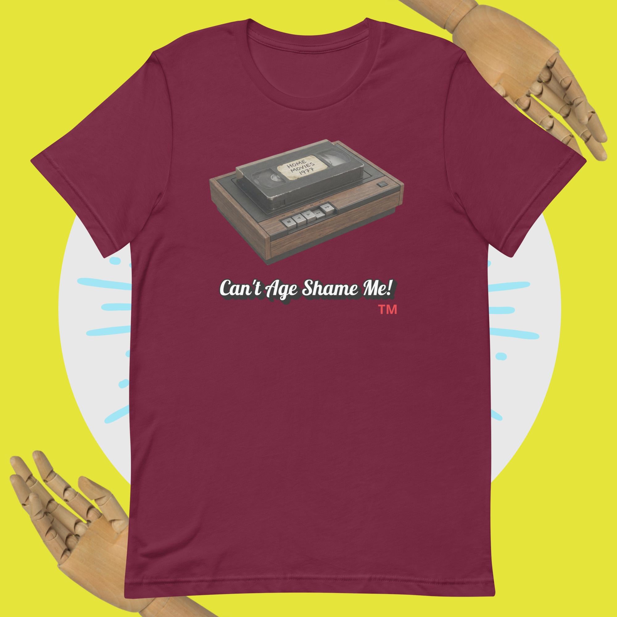 maroon  t-shirt with a cassette tape graphic and 'Can't Age Shame Me!' text on a yellow background.