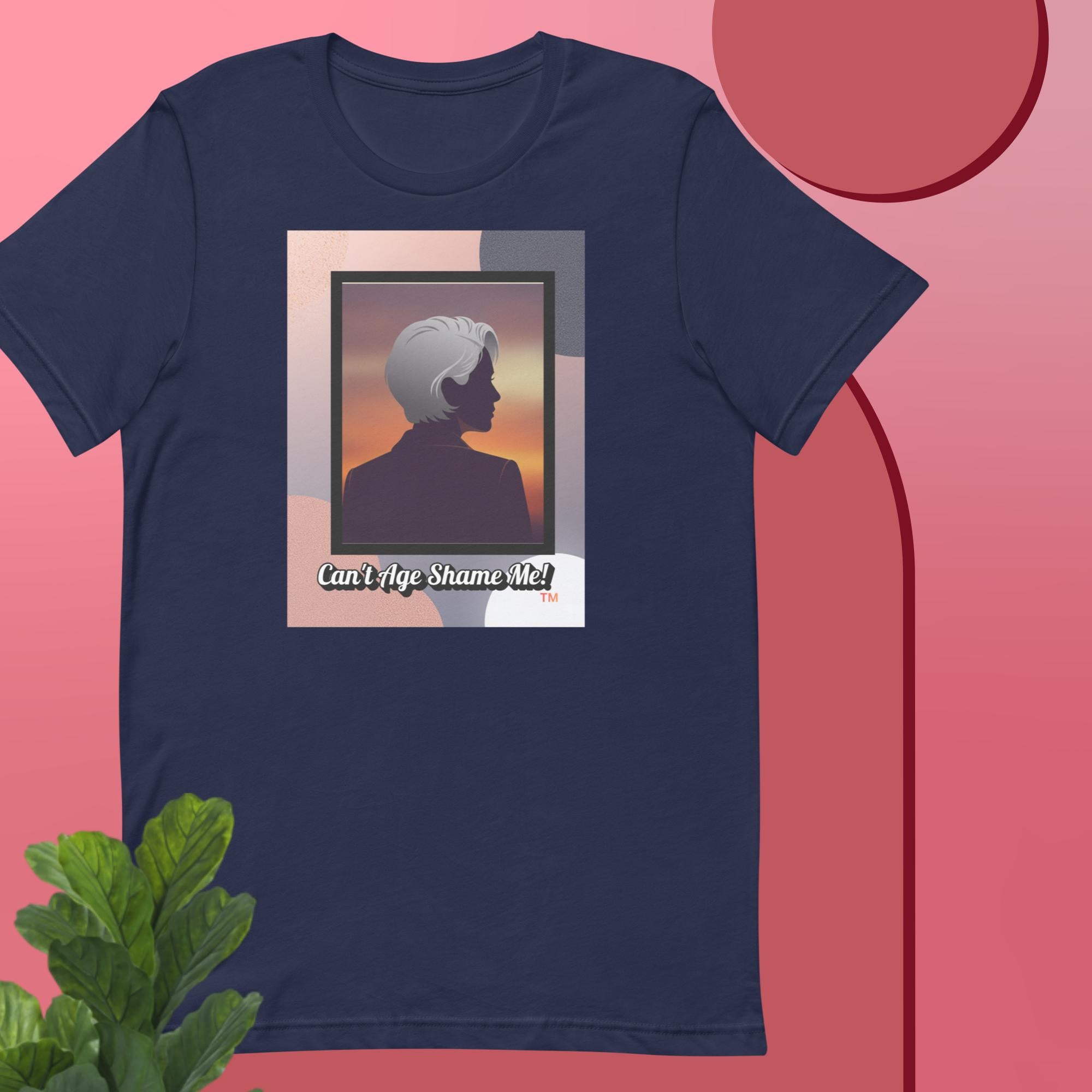 Navy t-shirt with a graphic design featuring a woman with gray hair silhouette and text: Can’t Age Shame Me! on a pink background.


