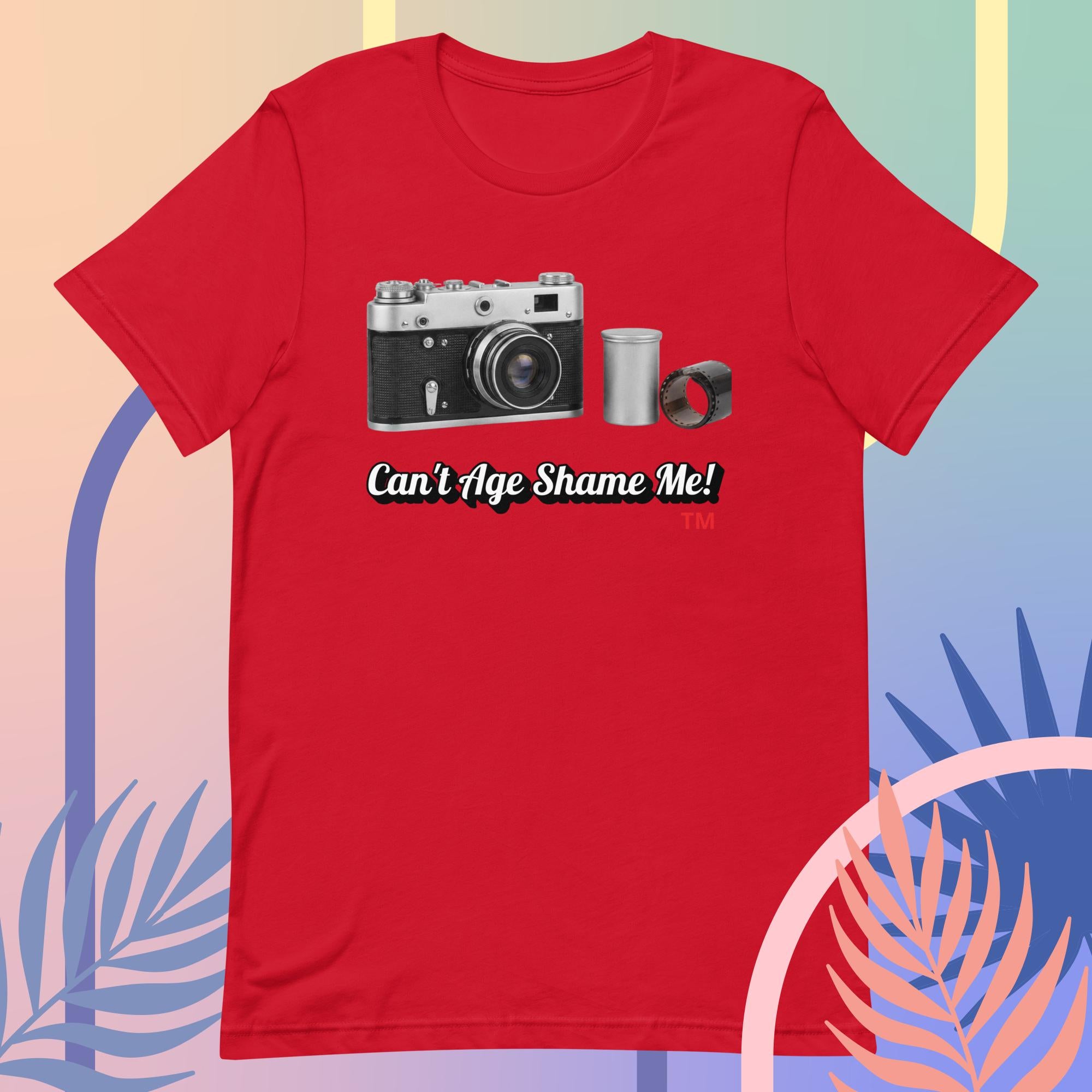 Red t-shirt with a camera graphic and text 'Can't Age Shame Me!' on a colorful background.