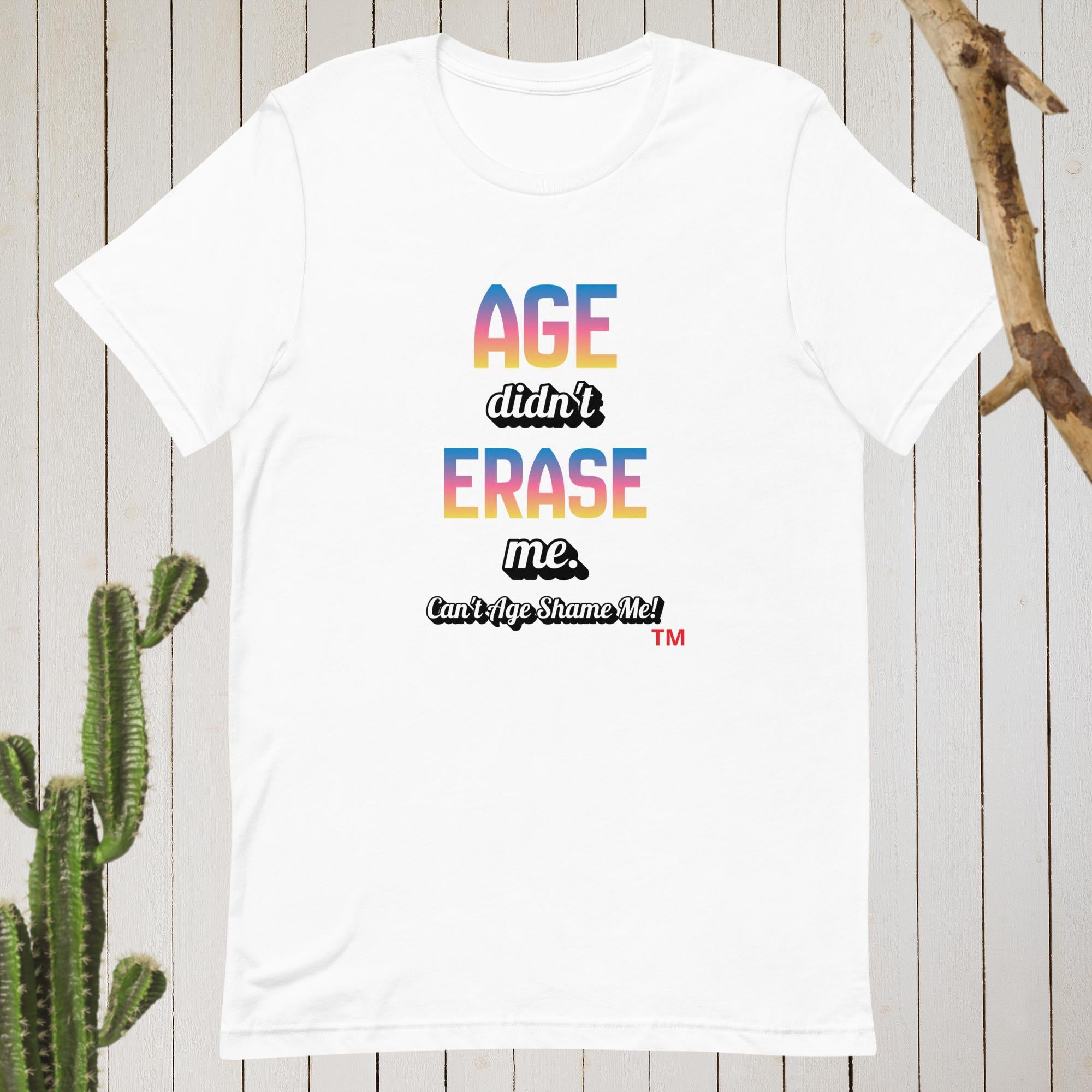 White t-shirt with colorful text on a wooden background with a cactus.