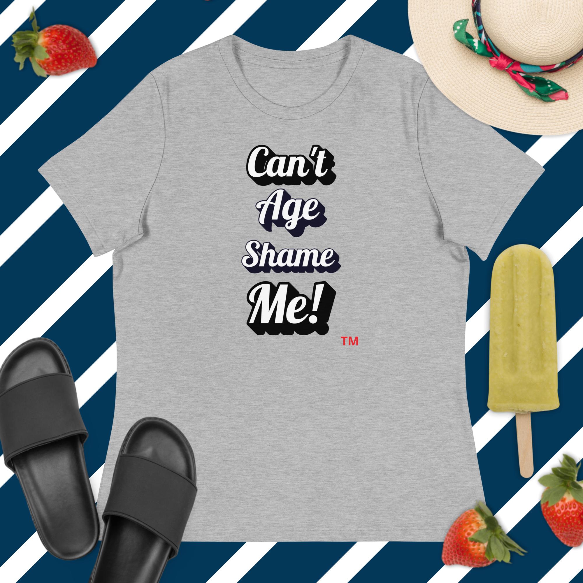 Gray t-shirt with 'Can't Age Shame Me!' text on a blue and white striped background with accessories.