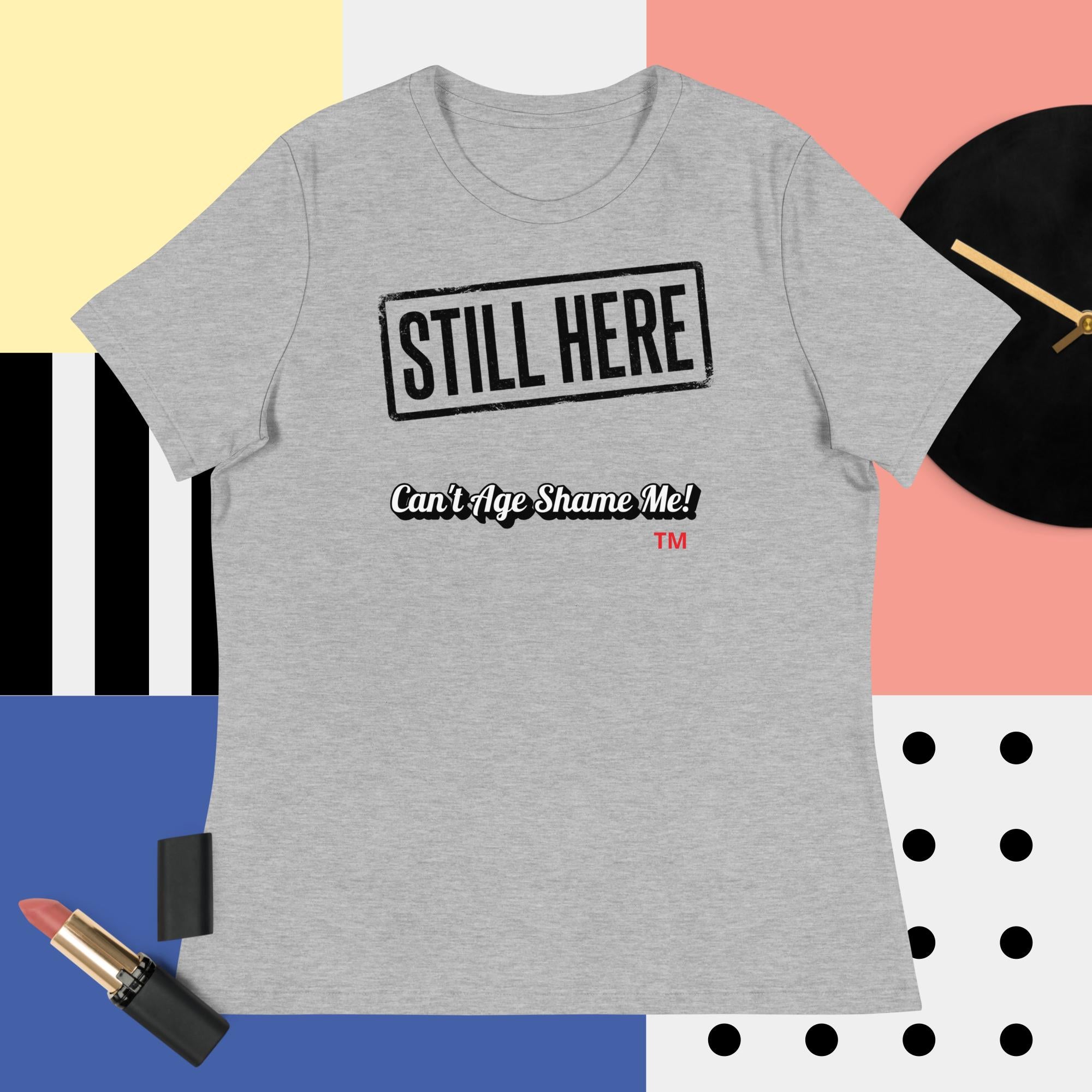 Gray t-shirt with 'STILL HERE Can't Age Shame Me' text on a colorful background