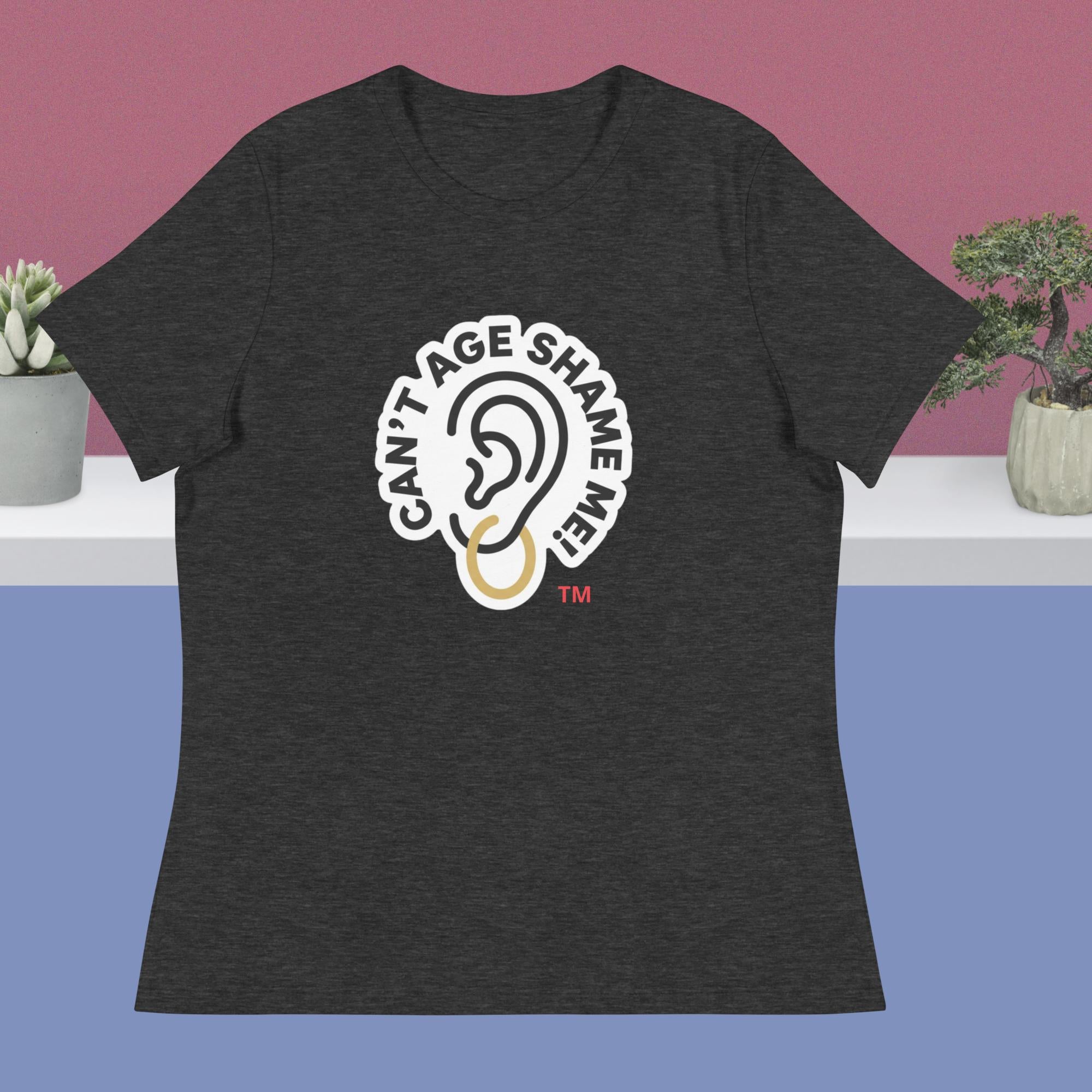 Dark gray t-shirt with 'Can't Age Shame Me' logo on a blue and pink gradient background