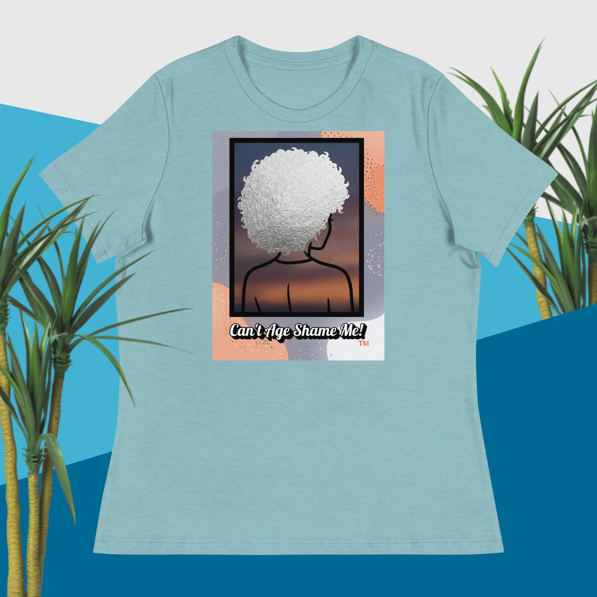 Light Blue t-shirt with a graphic design of a person with an afro and text 'Can't Age Shame Me!' on a blue and green plant background.