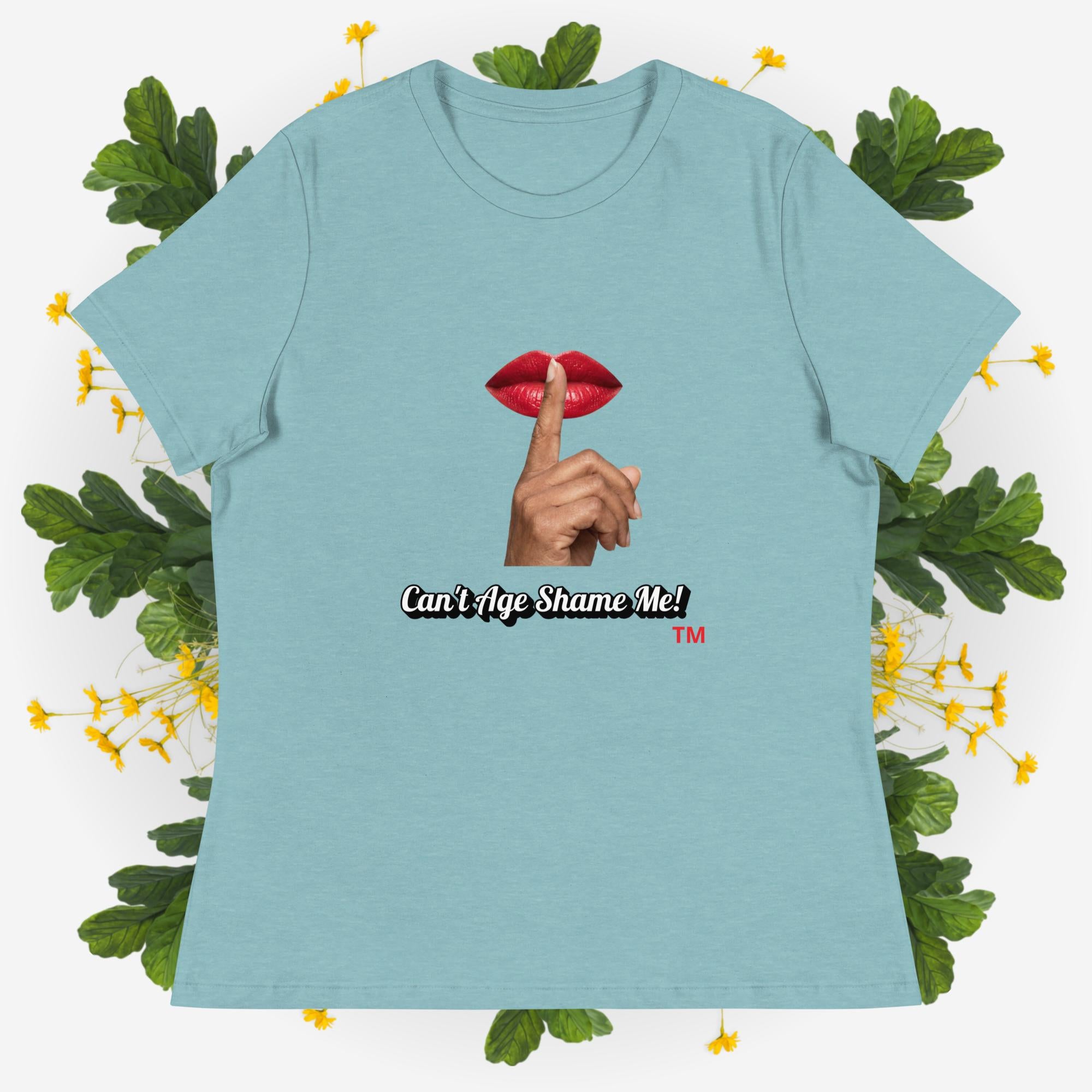 Blue Lagoon t-shirt with graphic design and text 'Can't Age Shame Me' on a decorative background with leaves and flowers.