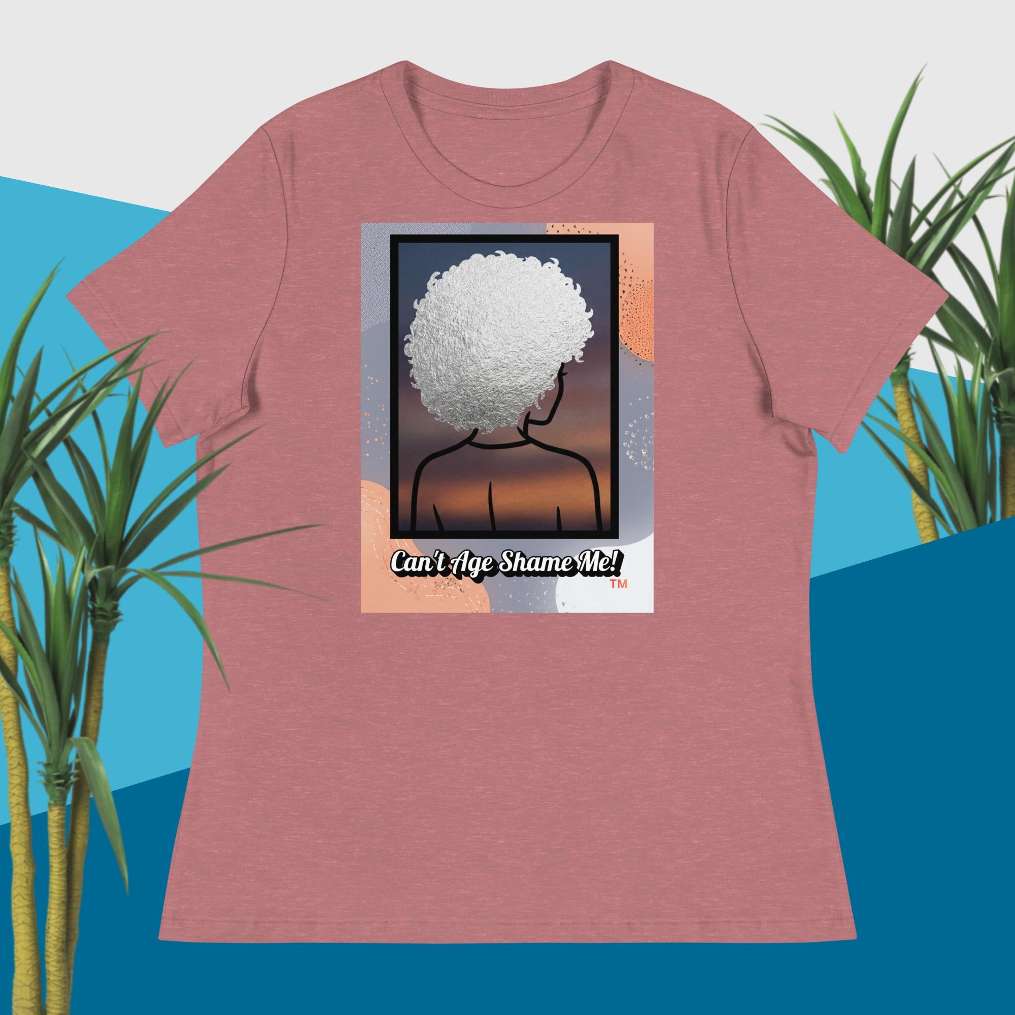 Mauve t-shirt with a graphic design of a person with an afro and text 'Can't Age Shame Me!' on a blue and green plant background.
