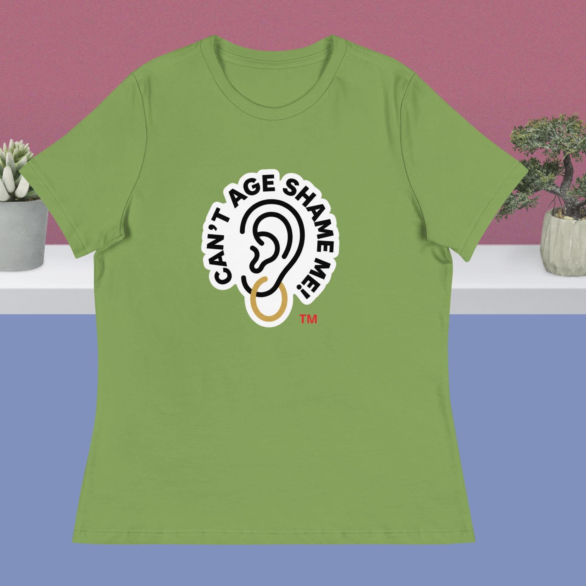 Green t-shirt with 'Can't Age Shame Me' logo on a blue and pink gradient background
