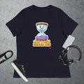 Navy blue t-shirt with a cartoon hourglass graphic design and text 'Can't Age Shame Me' graphic on a textured gray surface with a sneaker and headphones