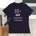 Navy t-shirt with colorful text design on a wooden surface with pens.
