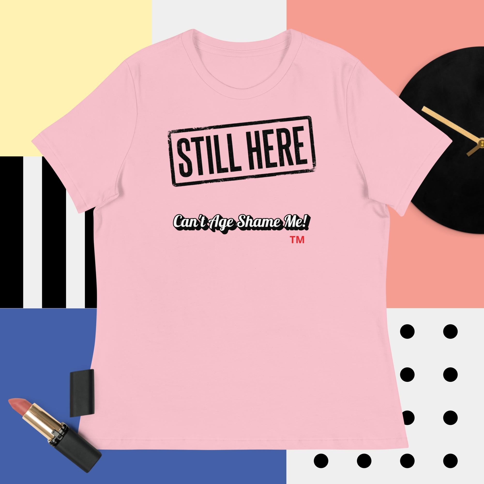 Pink t-shirt with 'STILL HERE Can't Age Shame Me' text on a colorful background