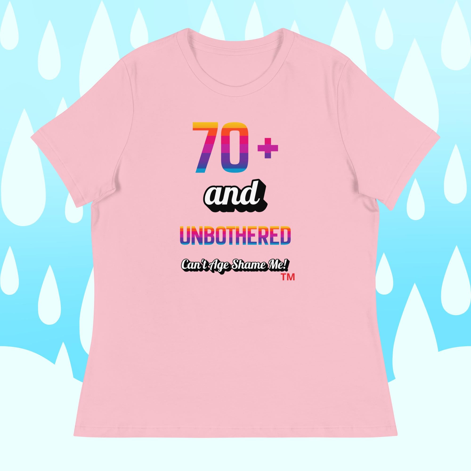 Pink t-shirt with colorful text design on a light blue background with white shapes.