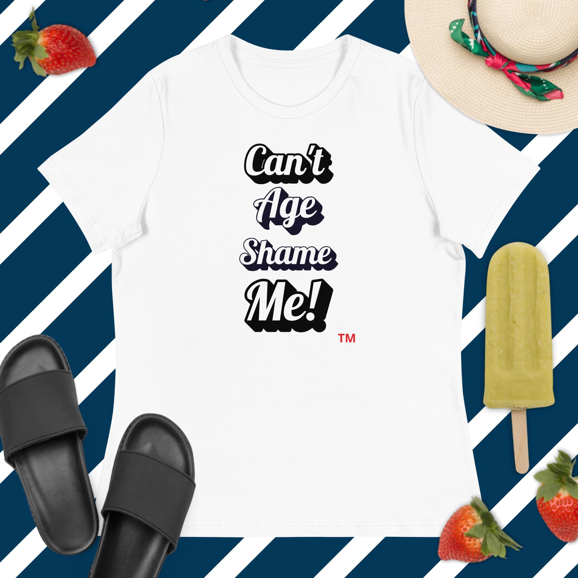 White t-shirt with 'Can't Age Shame Me!' text, black slides, green popsicle, and strawberries on a blue and white striped background.