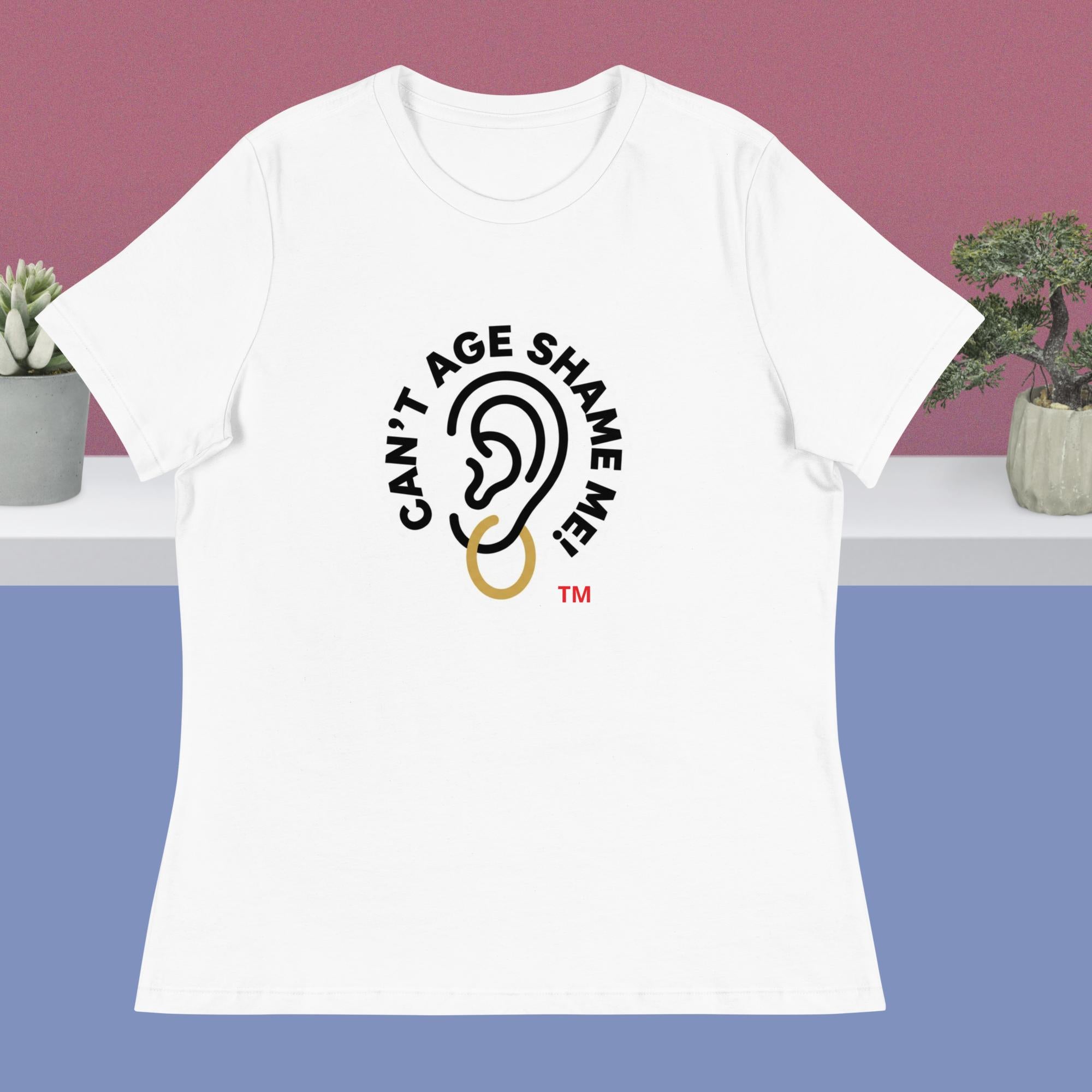 White t-shirt with 'Can't Age Shame Me' graphic design on a pink and blue gradient background.