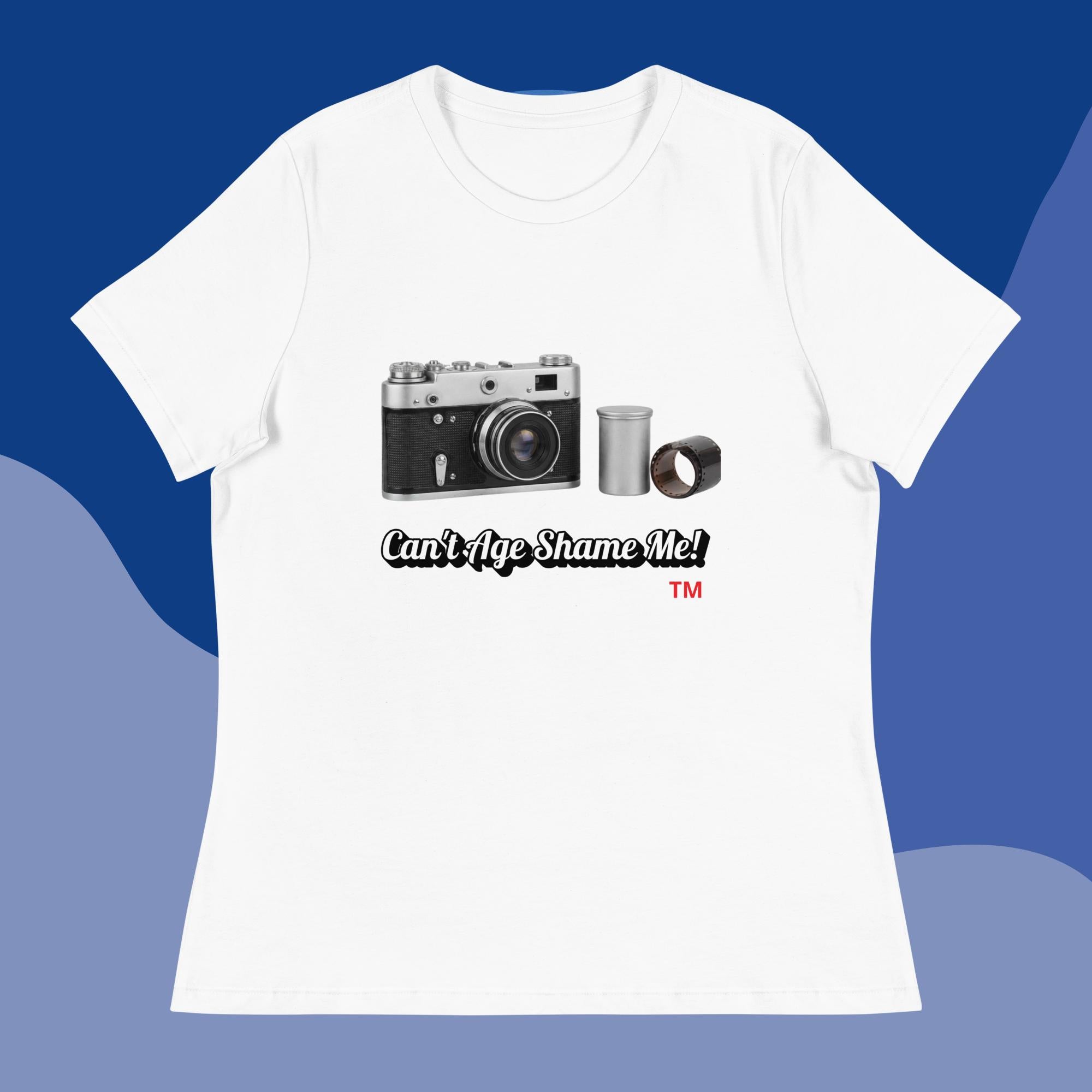 white  t-shirt with a camera graphic and text  can't age shame on on a blue background 